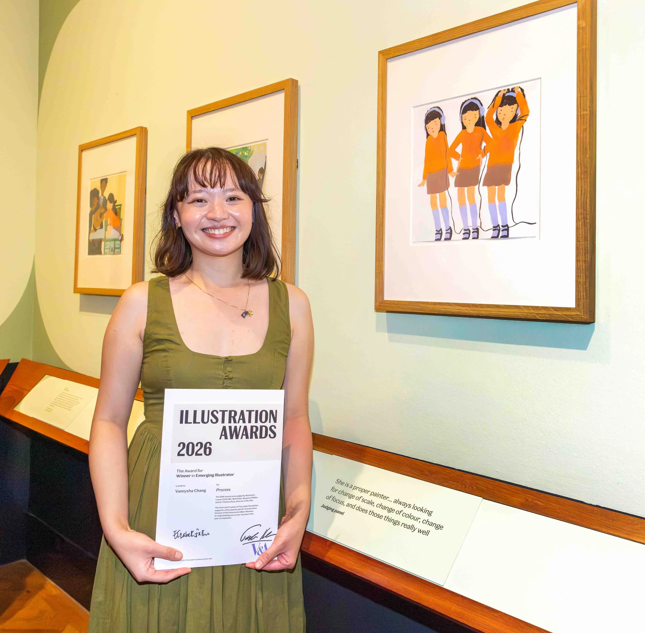 Vannysha, the illustrator, holding a certificate for winning the V&A Illustration Awards in 2026