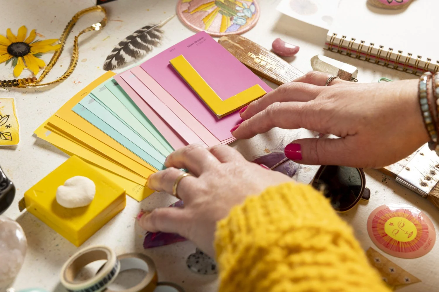 Finding the right design partner for authentic branding — hands arranging color swatches and creative tools at Most Beautiful Design studio.