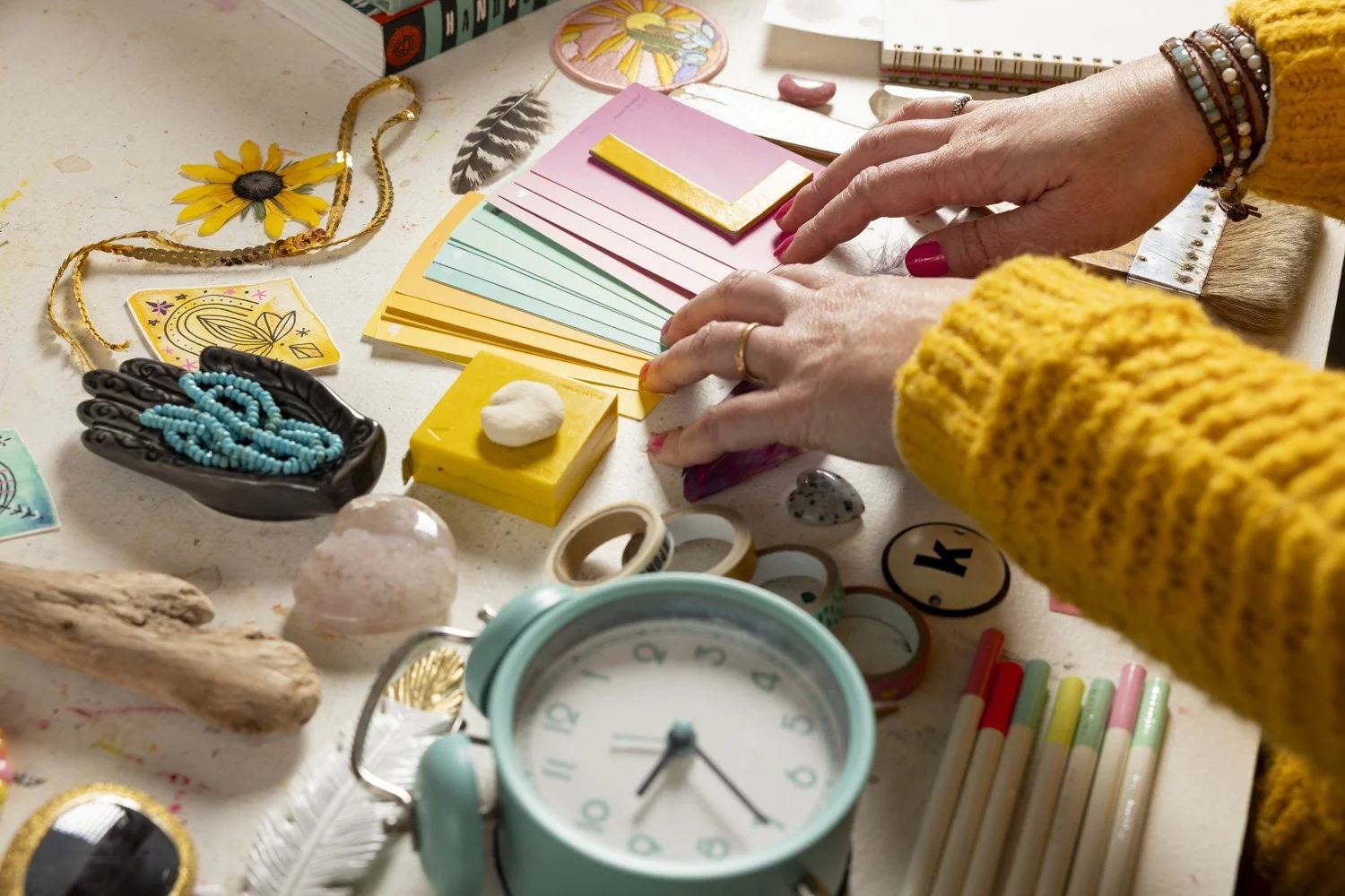 Hands arranging colorful design materials on a creative workspace — representing collaboration, clarity, and authentic branding at Most Beautiful Design.