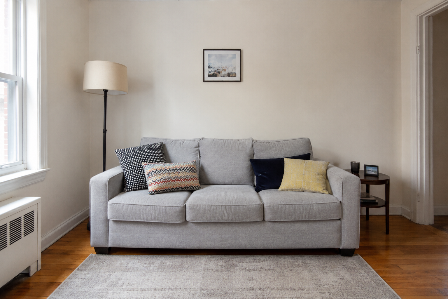 Living room with mismatched cushions and basic furniture — illustrative example