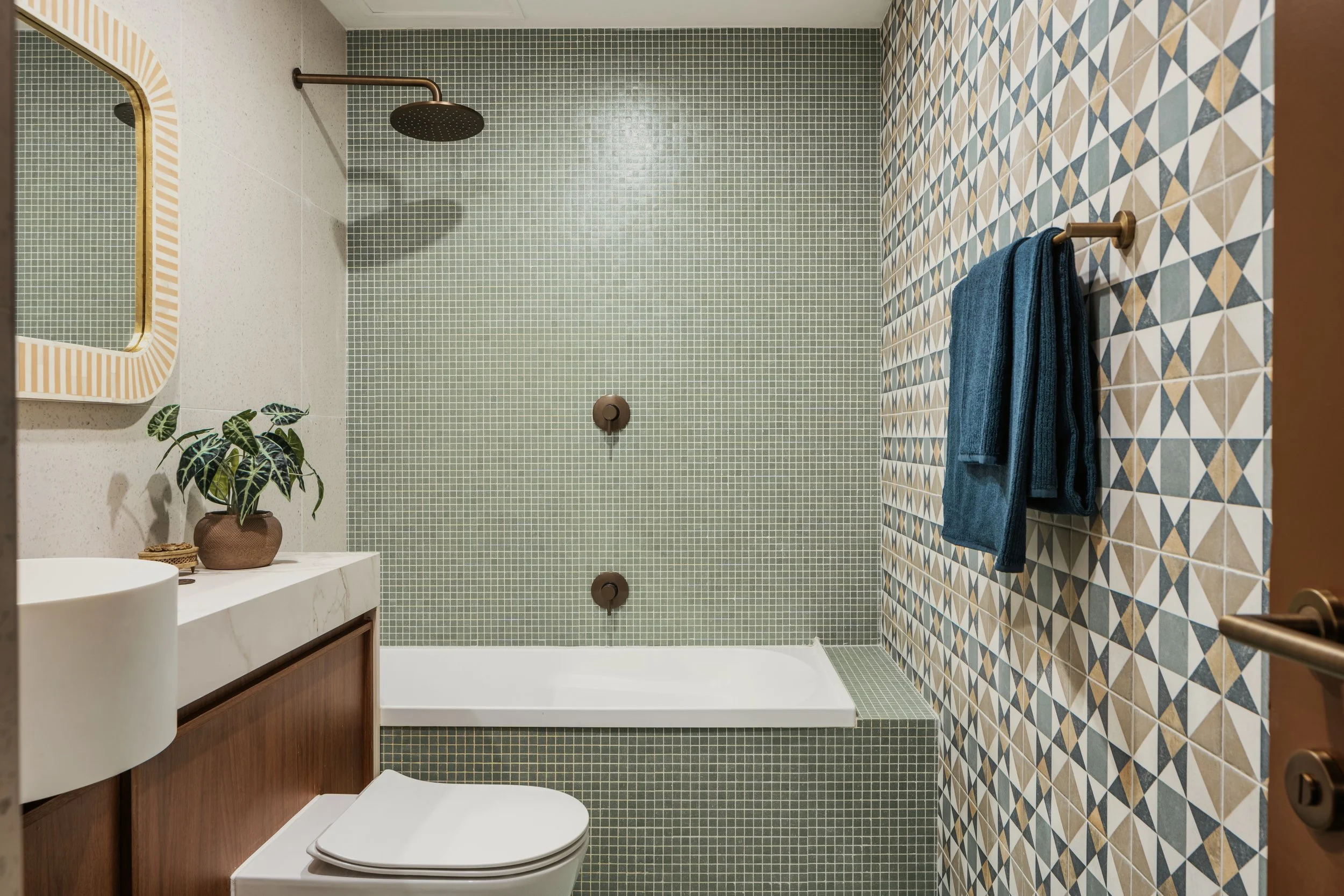 Bathroom after surface renovation — updated mosaic tile wall and styled accessories — SYP Homes Sydney