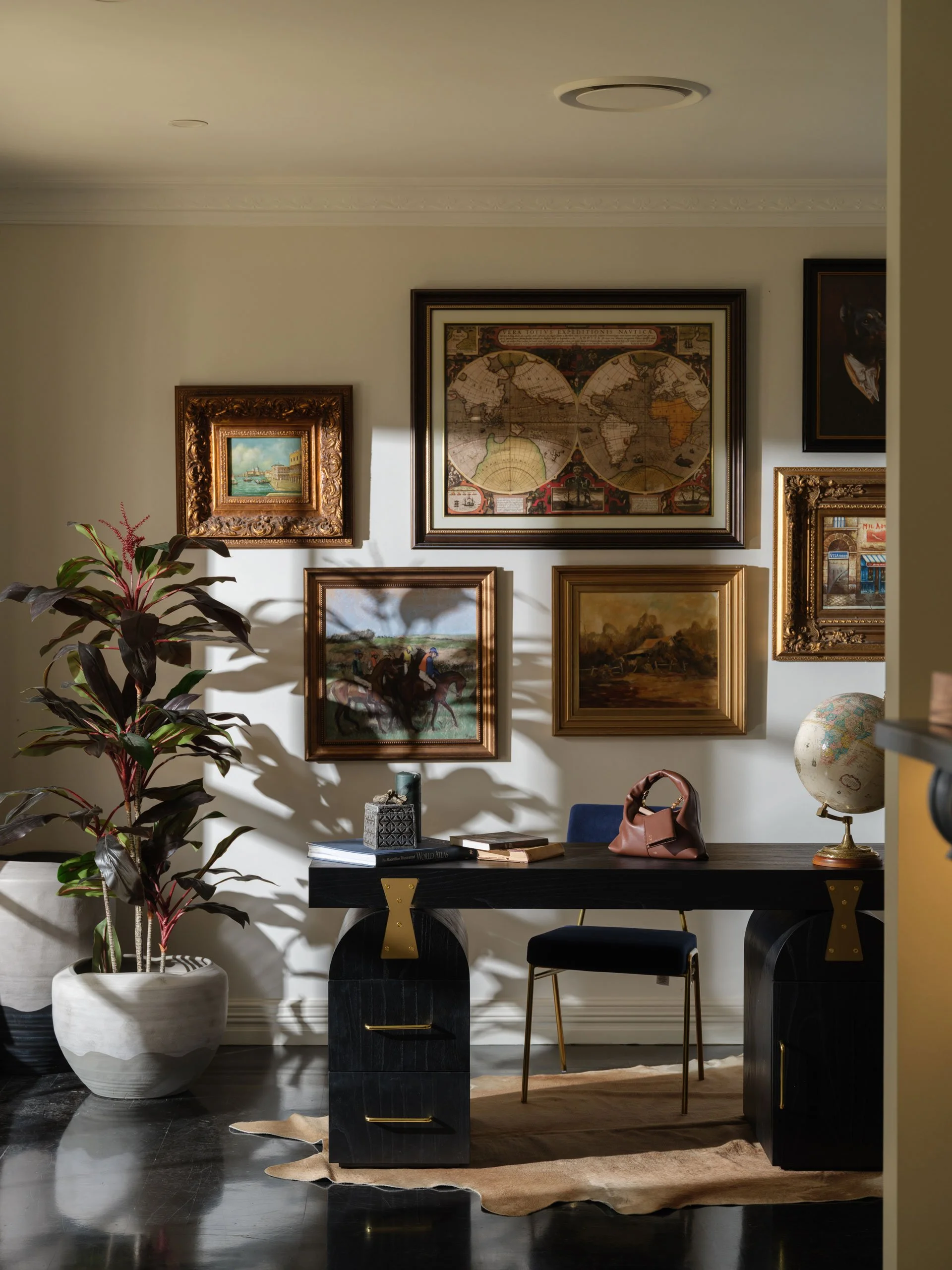 Gallery wall artwork styling in a home workspace