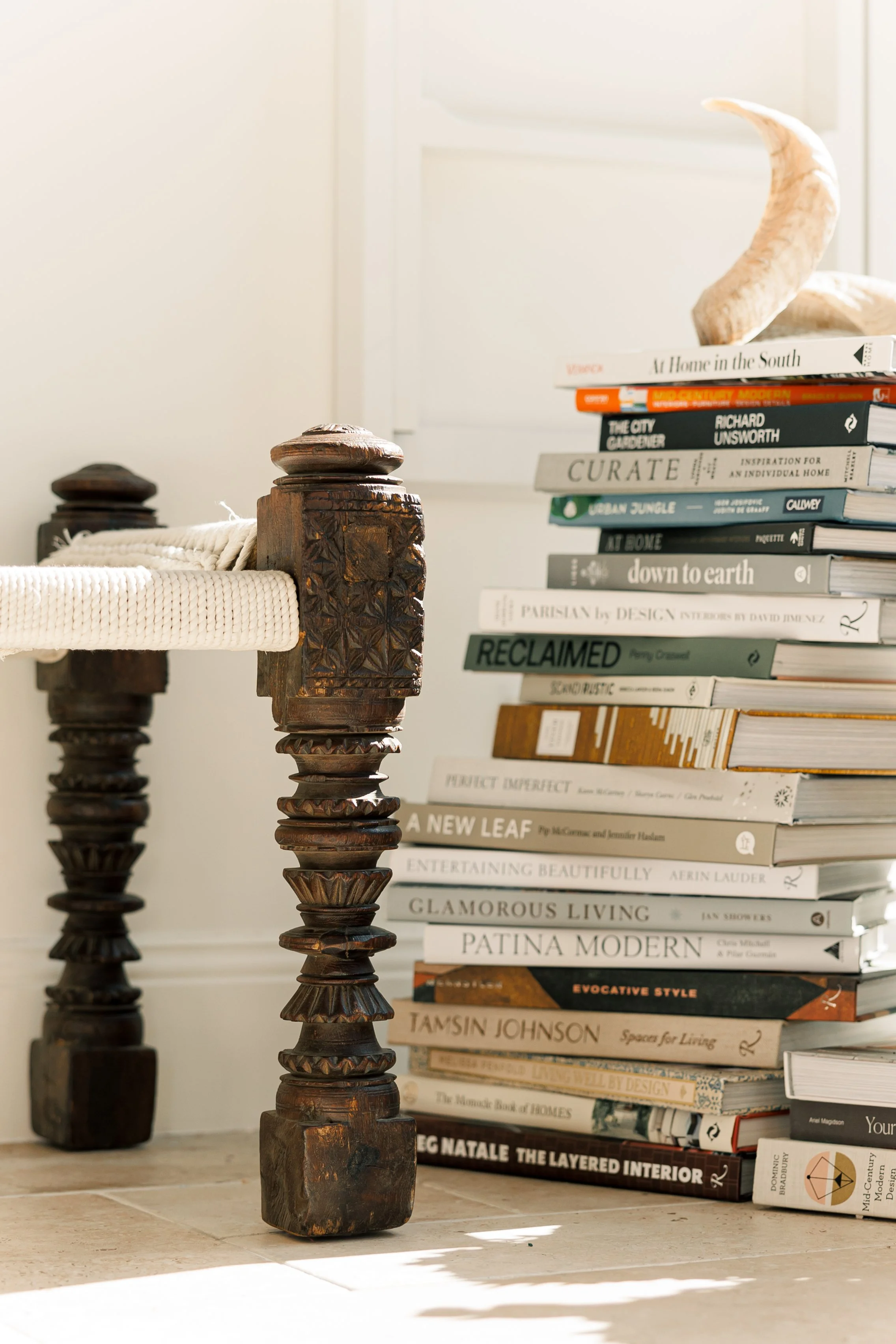 A styled living room corner with stacked books and decorative objects — bespoke interior styling, Sydney and beyond, SYP Homes