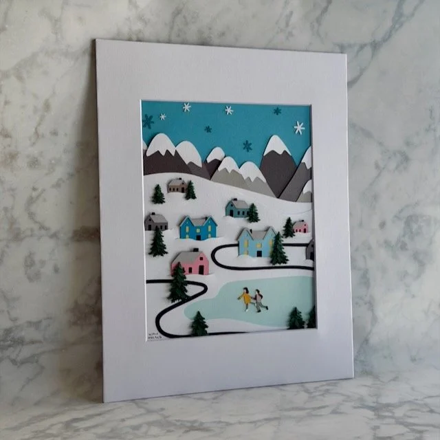 Winter Wonderland paper illustration shown at an angle, trees, houses, and snow in raised layers