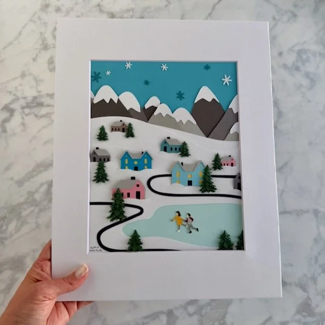Winter Wonderland Village 8x10 original paper illustration in an 11x14 mat, held in a woman's hand for size