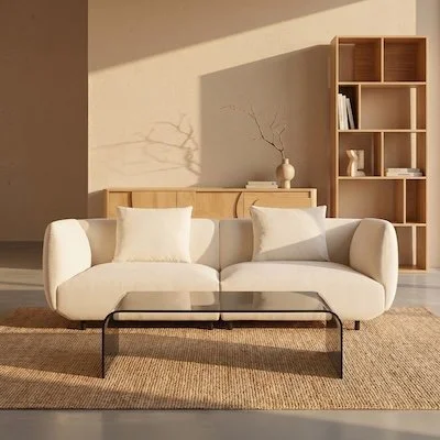 White sofa and glass coffee table in warmly lit room.
