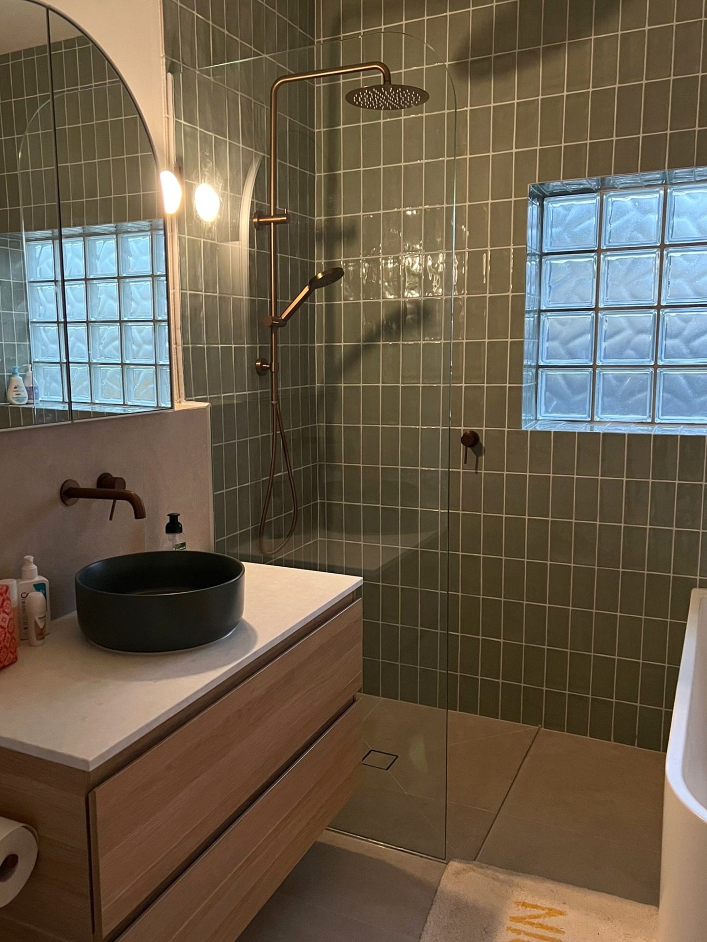 We love seeing how our clients live in their new spaces.
Swipe to see the before photos.

One element we particularly loved about this project was the glass-tiled window. It was important to incorporate this feature into the new design while improvin