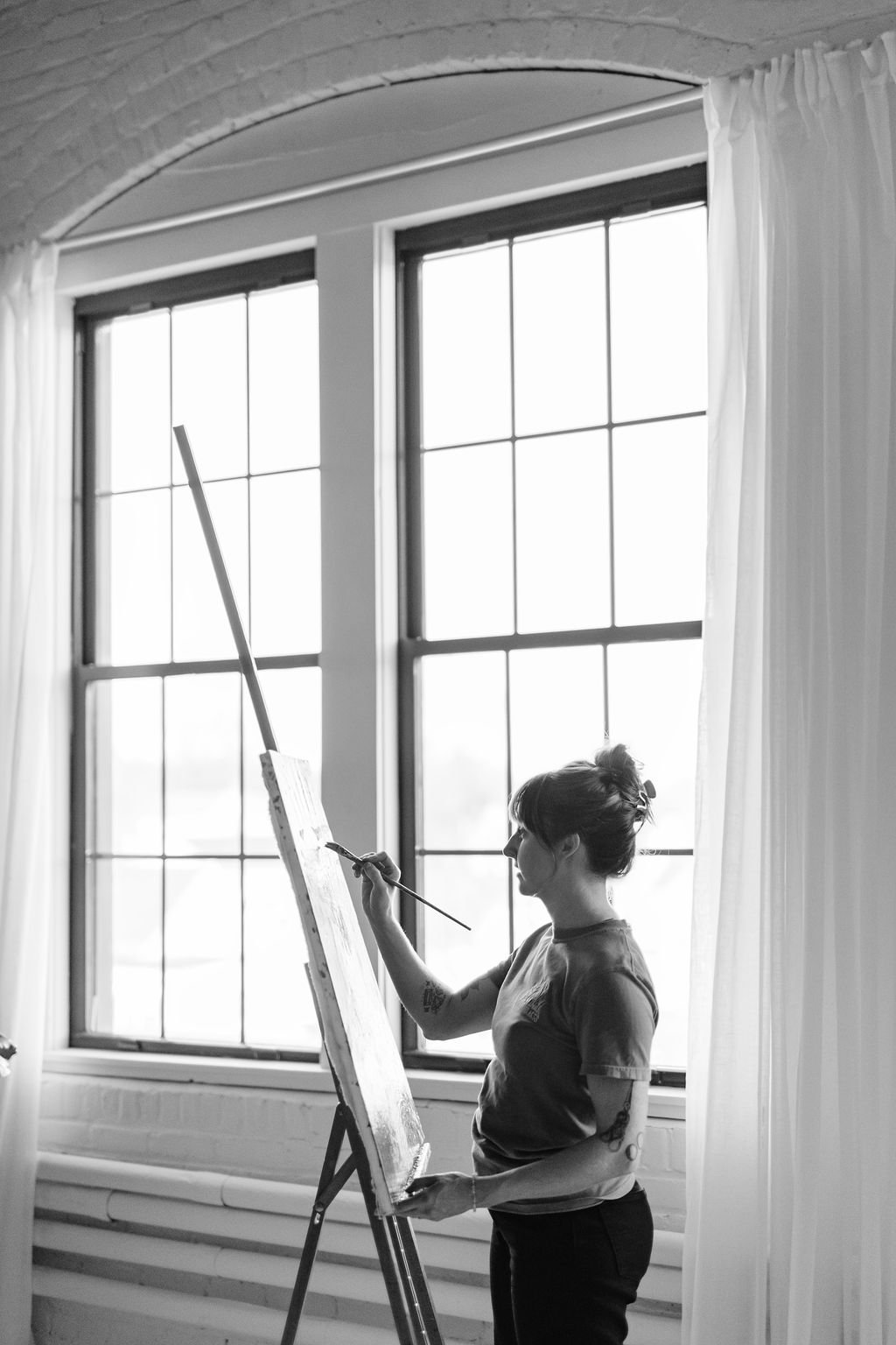 Artist Beth Bailey Painting in her studio on an easel