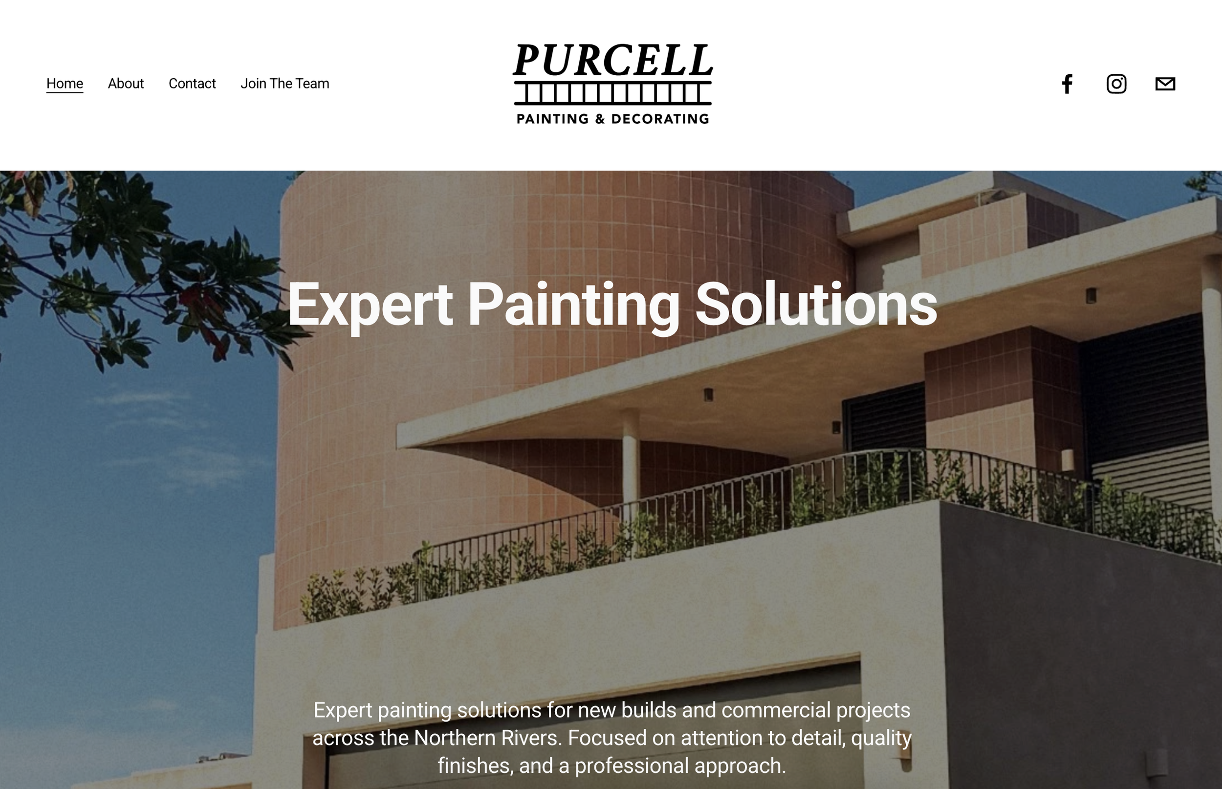 Two young men sitting on a stone ledge, one in a white t-shirt and the other in a yellow t-shirt with a cap turned backwards, engaging in conversation.