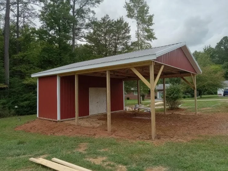 Red and white pole barn tractor shed with an enclosed feed storage room