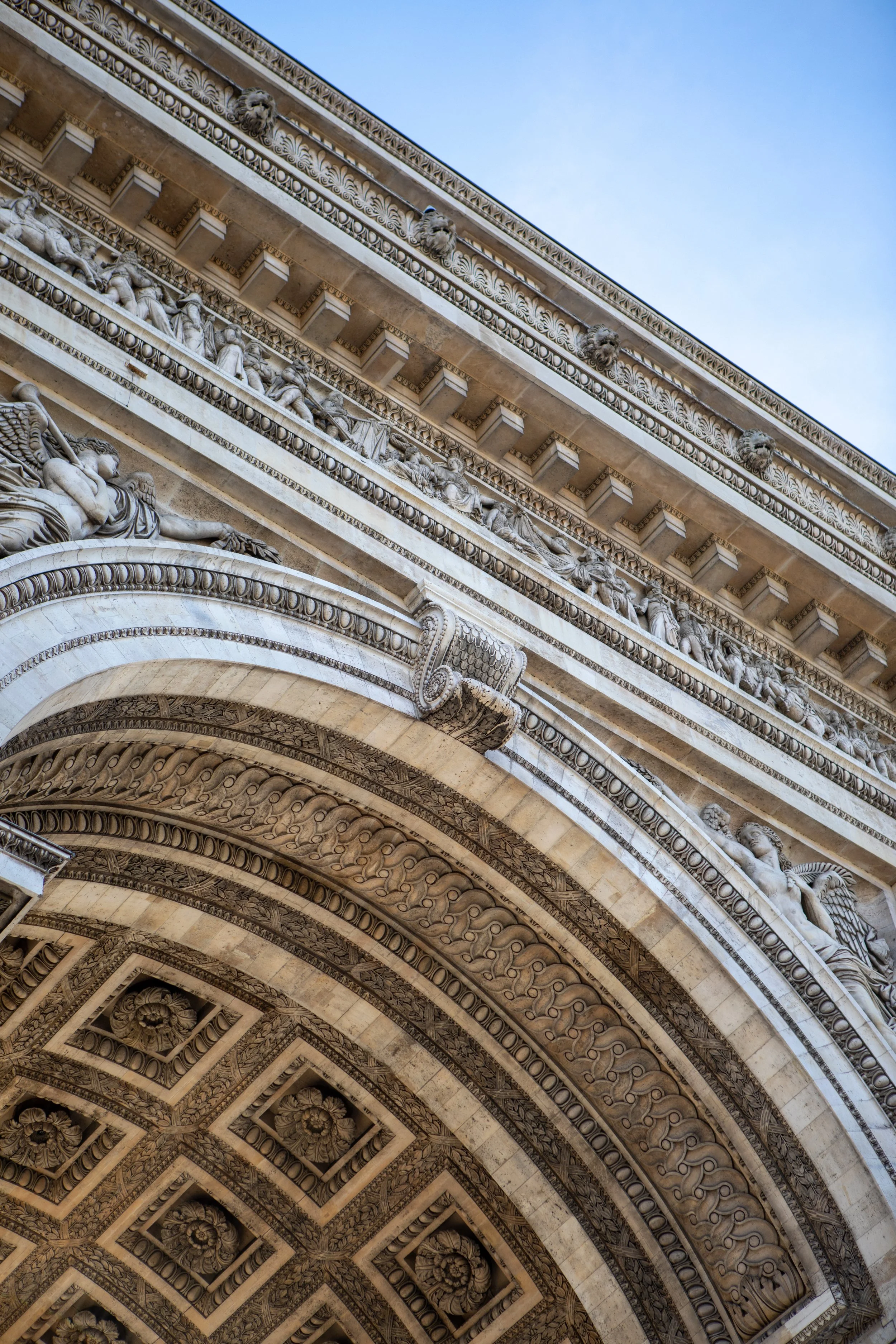 Close-up of the ornate architectural details and sculptures on the Arc de Triomphe in Paris, France.