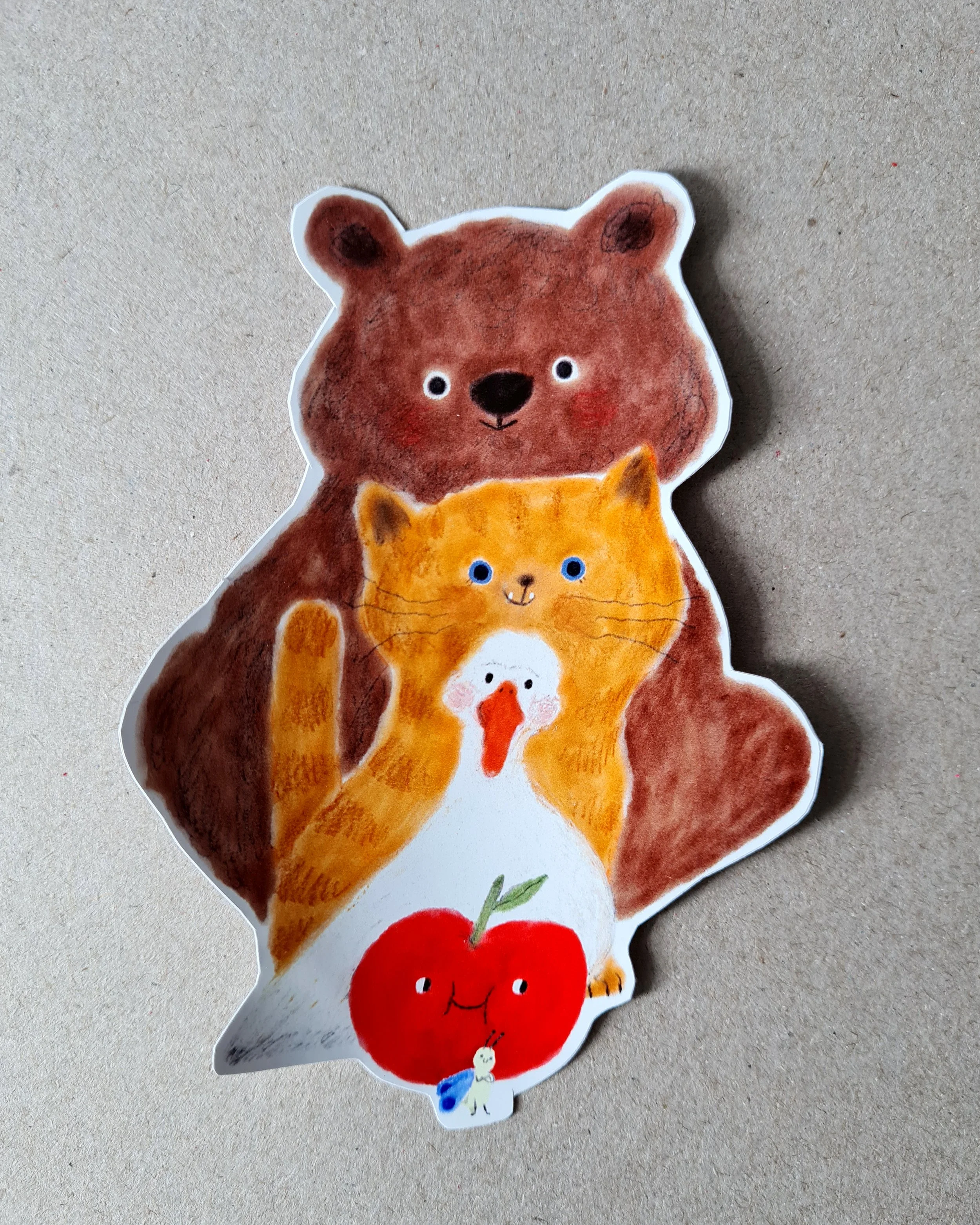 A bear a cat a duck an apple and a warm in line, all smiling