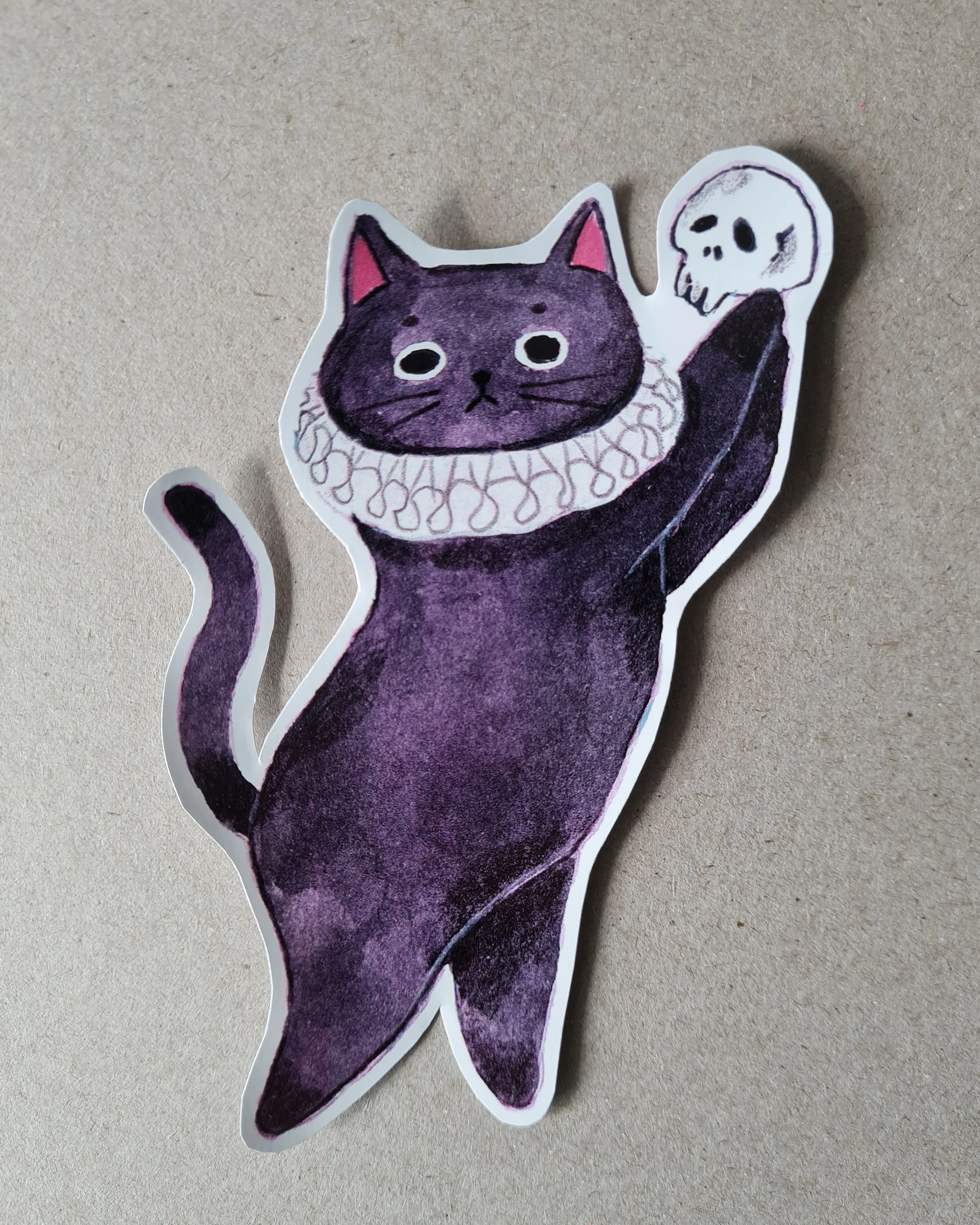 black cat posing with a skull like the famous Hamlet scene