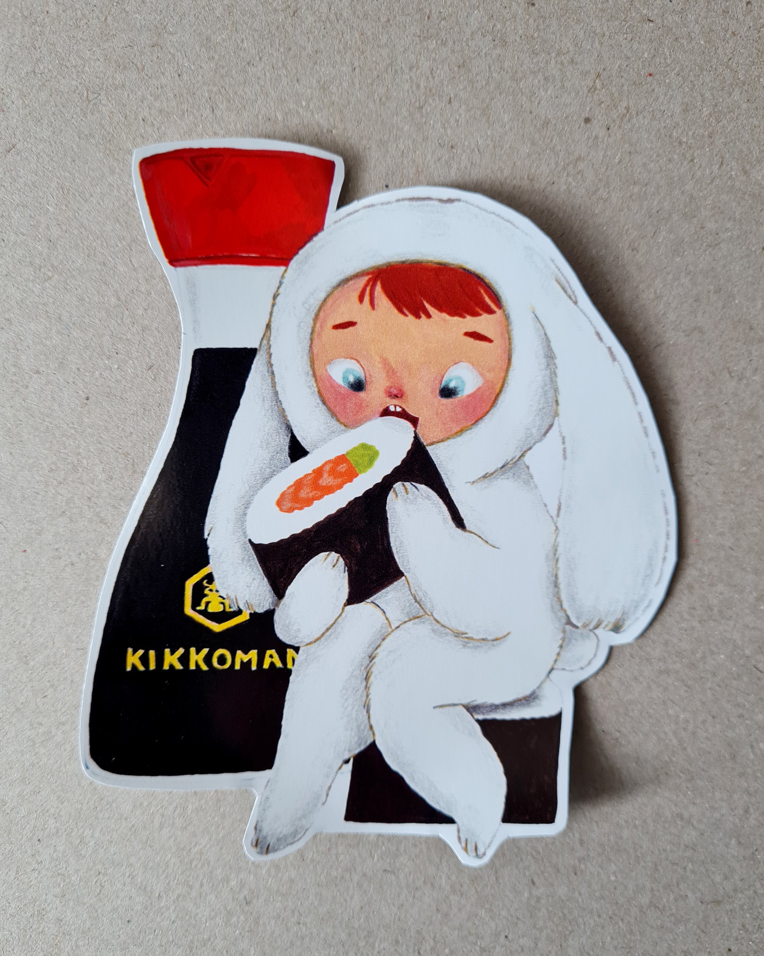 a petit girl dressed as a bunny holding a massive sushi the size of her head