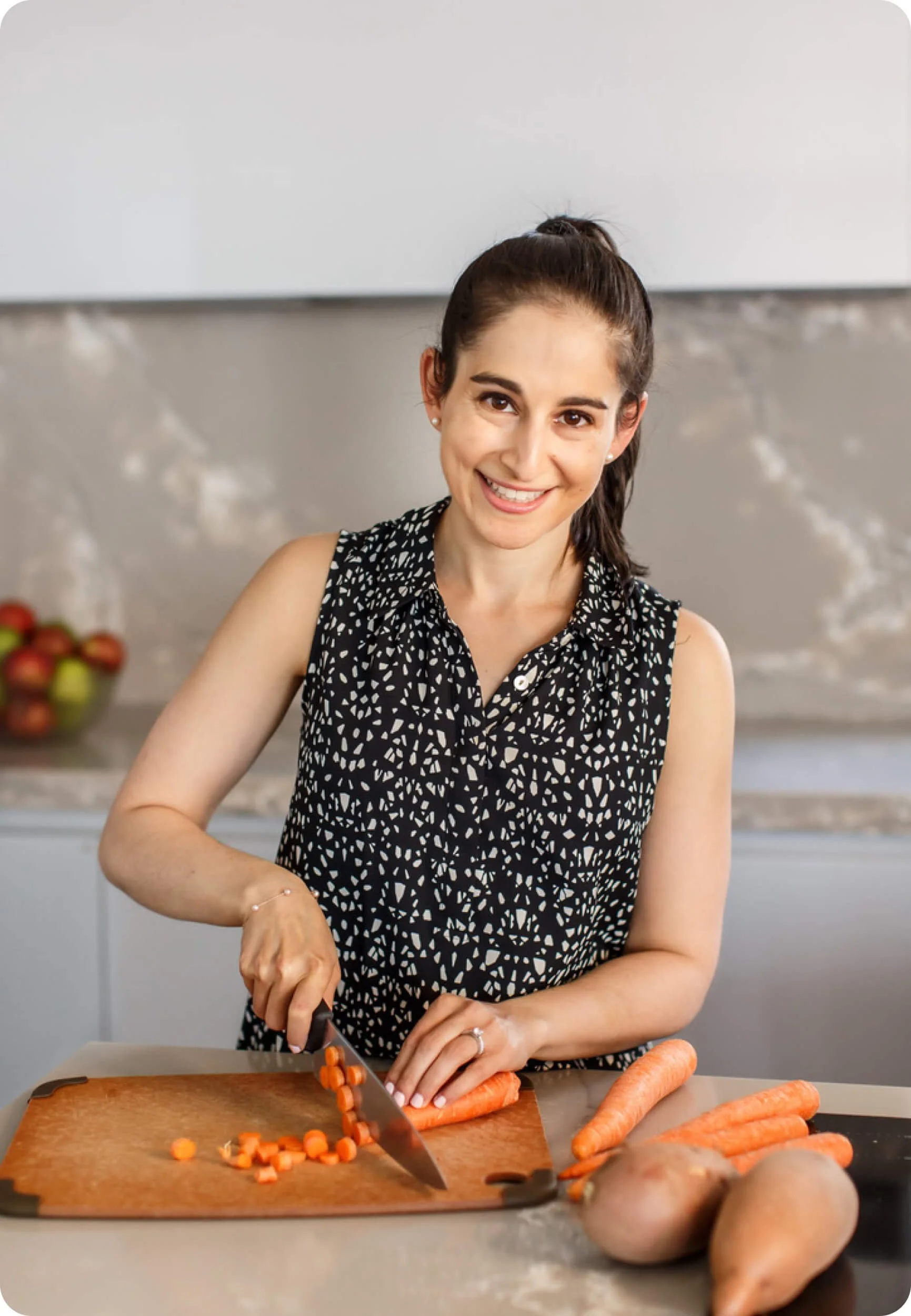Melissa Schuster, registered dietitian, chopping carrots in her kitchen.