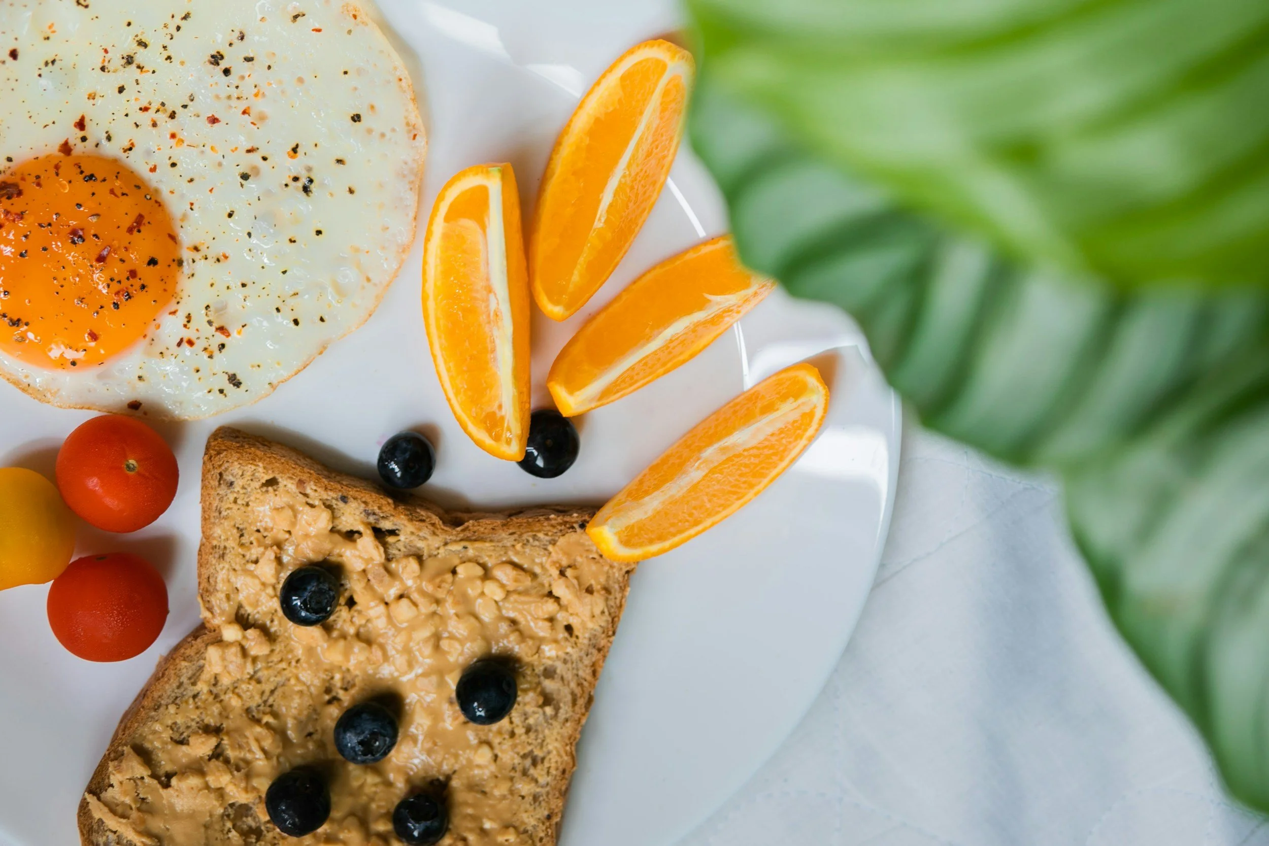 5-minute balanced back to school breakfast of peanut butter toast with a fried egg and fruit.