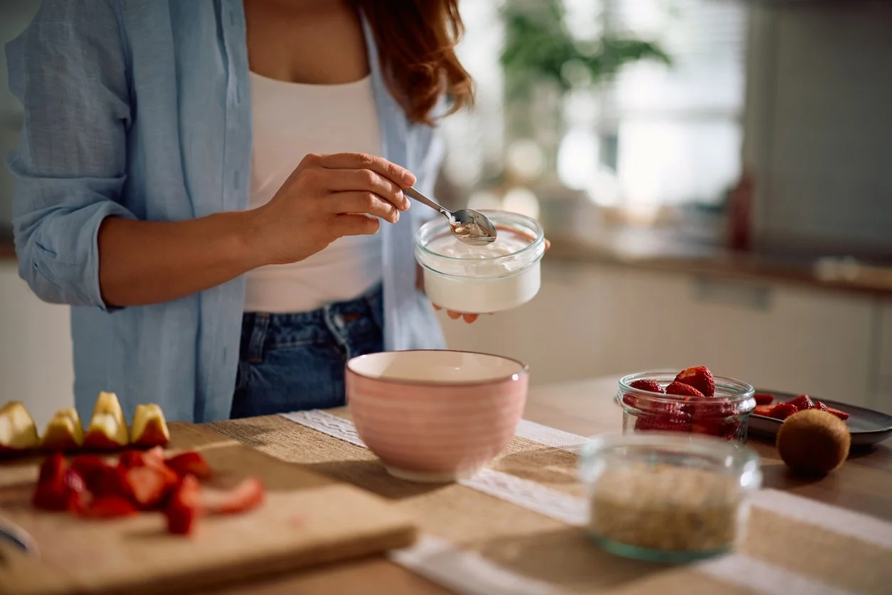 Woman preparing a balanced breakfast in the morning, supporting energy, hormones, and digestion.