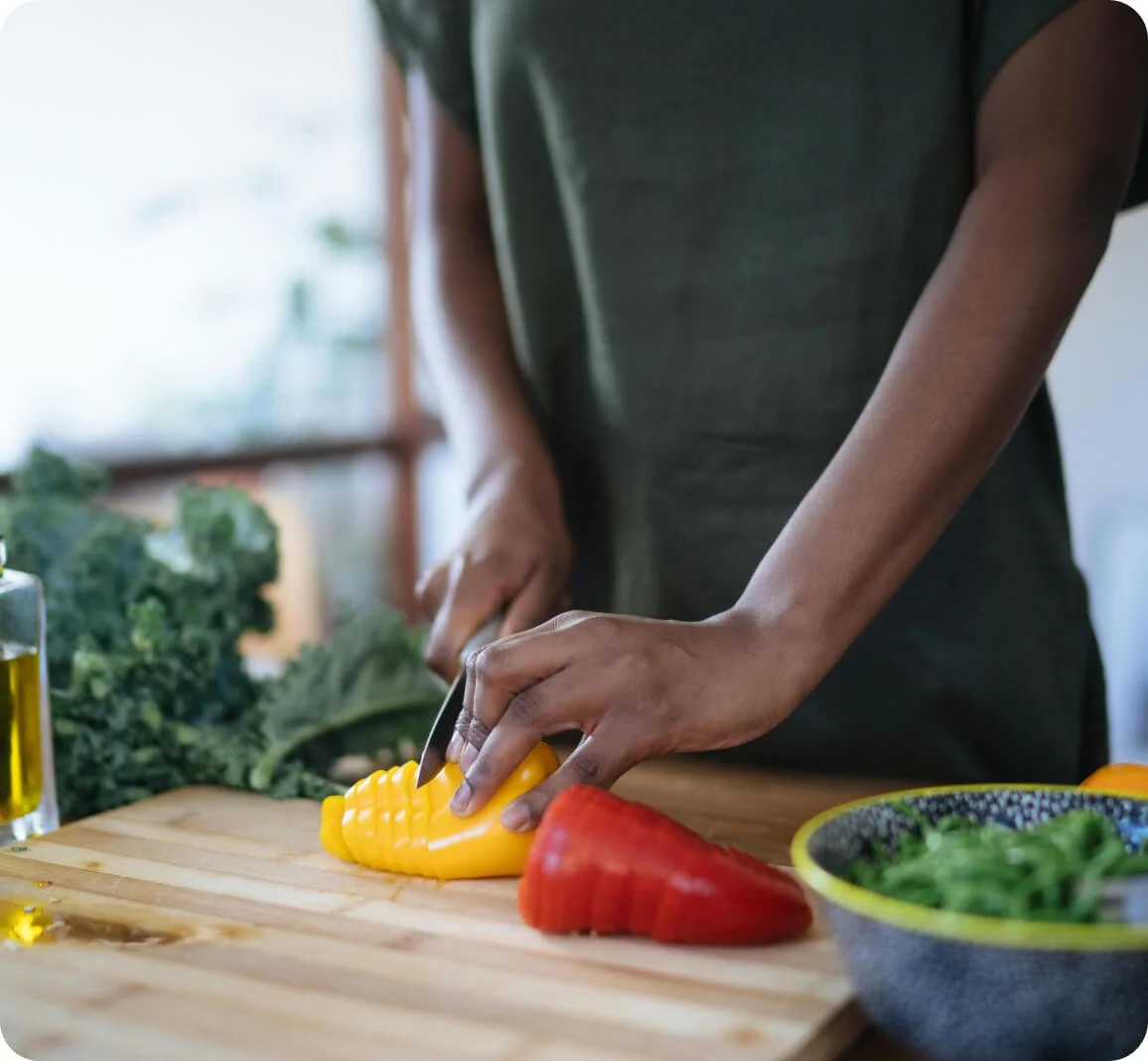 Person chopping fresh vegetables as part of a six-week nutrition bootcamp health reset program