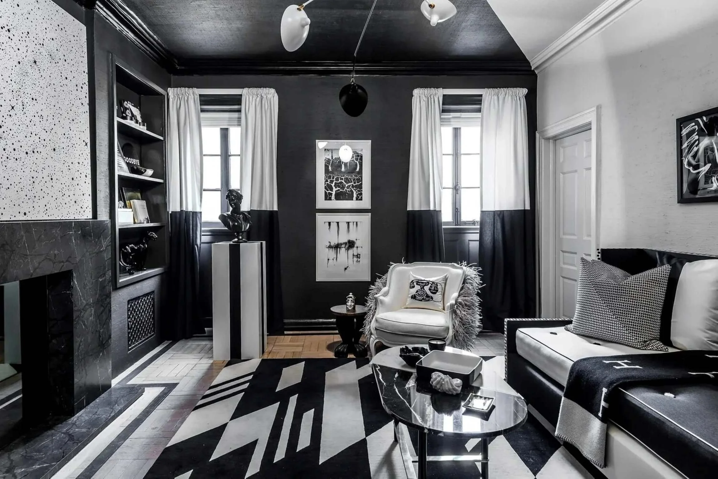 Holiday House showcase living room with a black ceiling, marble fireplace and layered monochrome furnishings.
