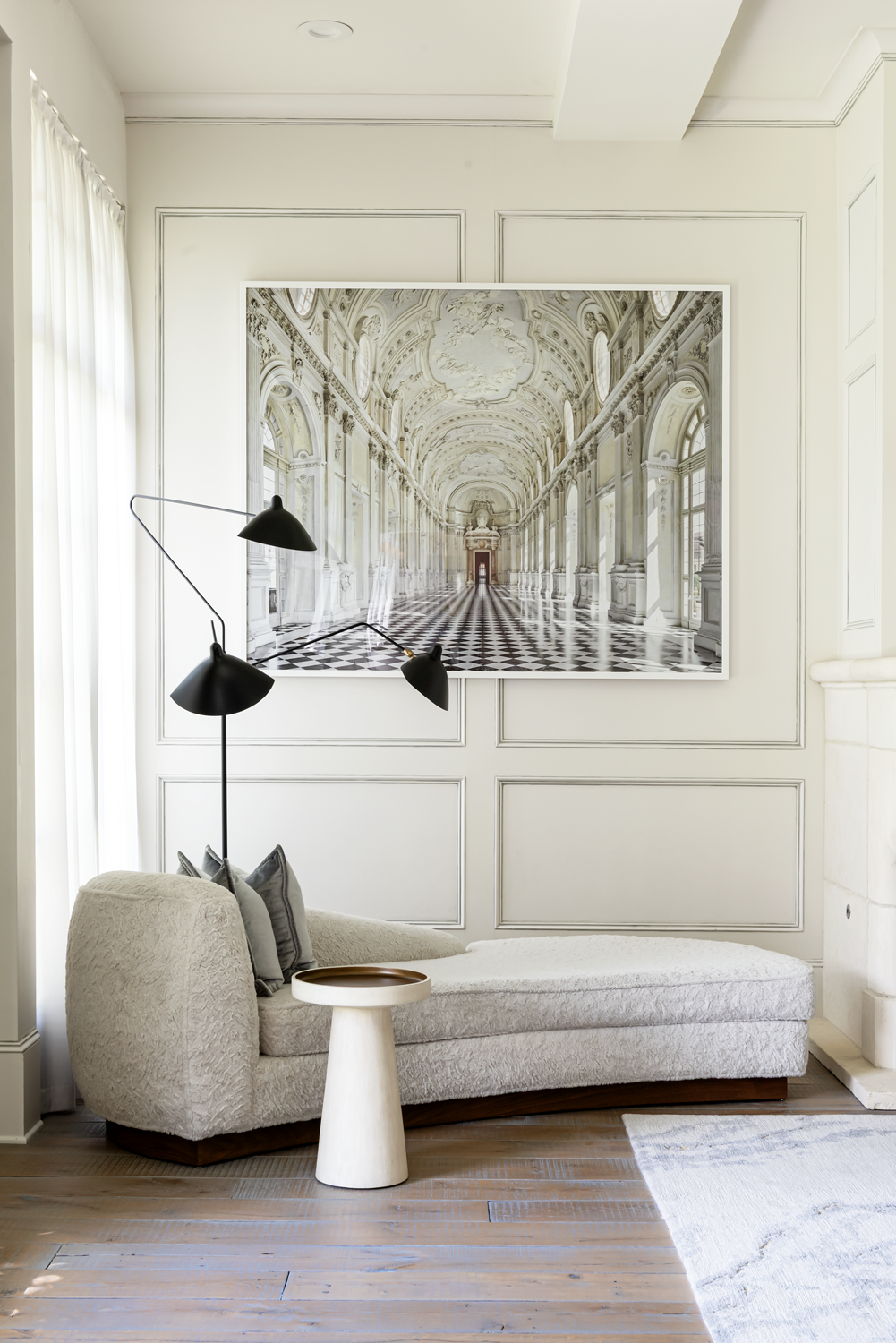 French country home in Houston living room with a curved chaise, black floor lamp and large architectural artwork.