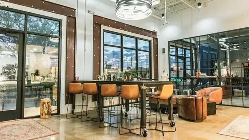 Commercial interior design project at Cavo Coffee, with leather bar stools, black-framed glazing and concrete floors.