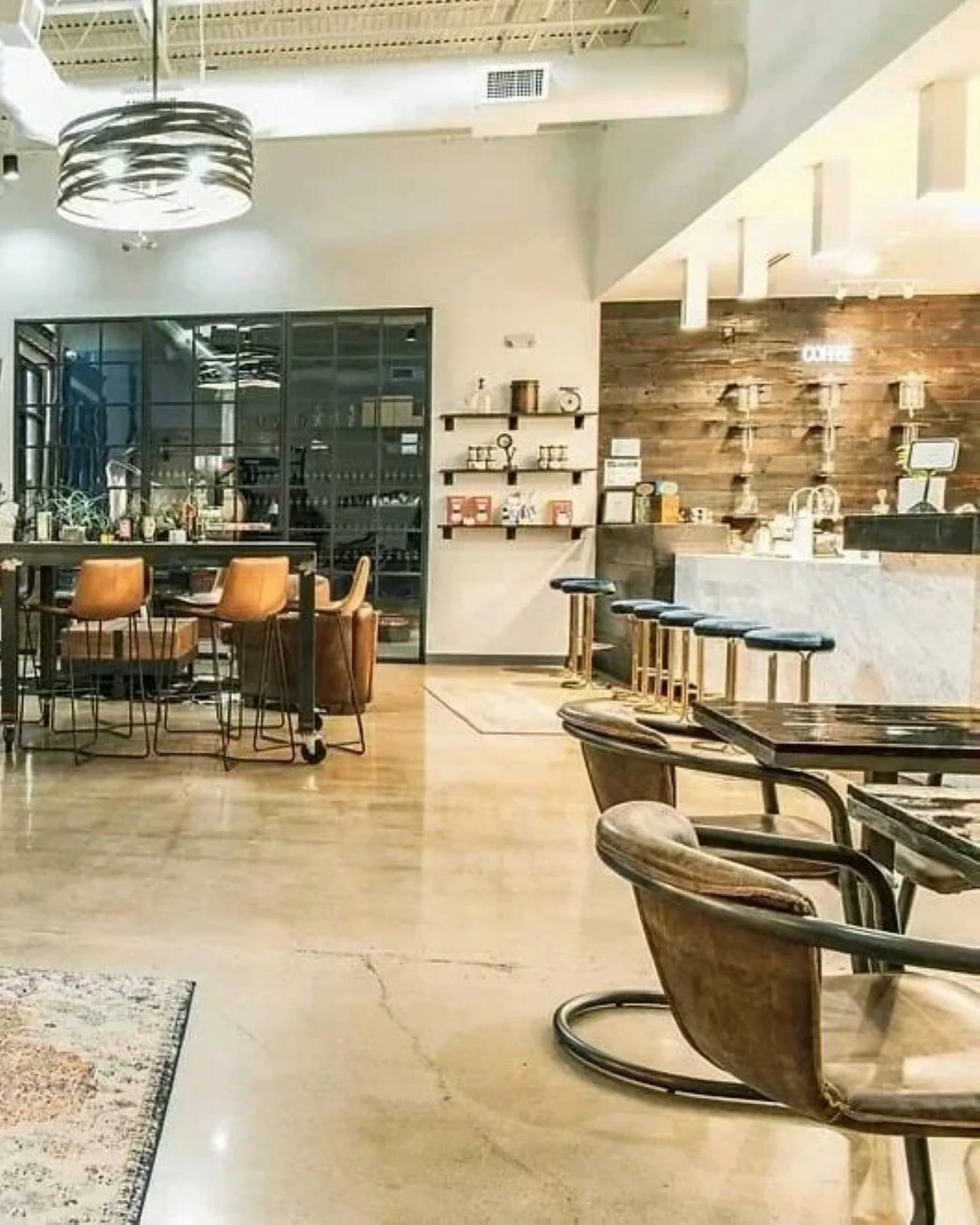 Cavo Coffee interior with marble service counter, timber feature wall, café seating and polished concrete flooring.