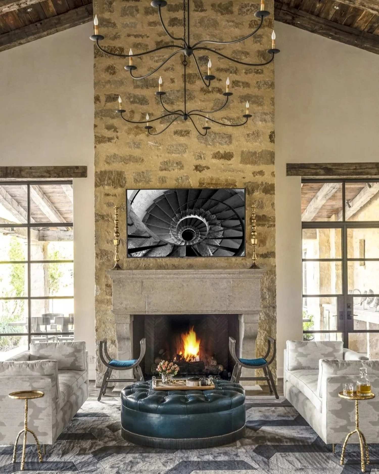 Luxury residential interior project at Houston Oaks, featuring a stone fireplace, sculptural chandelier and tailored seating.