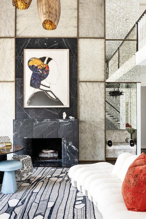 Interior designer New York Greenwich Village living room with a black marble fireplace, layered art and sculptural lighting.