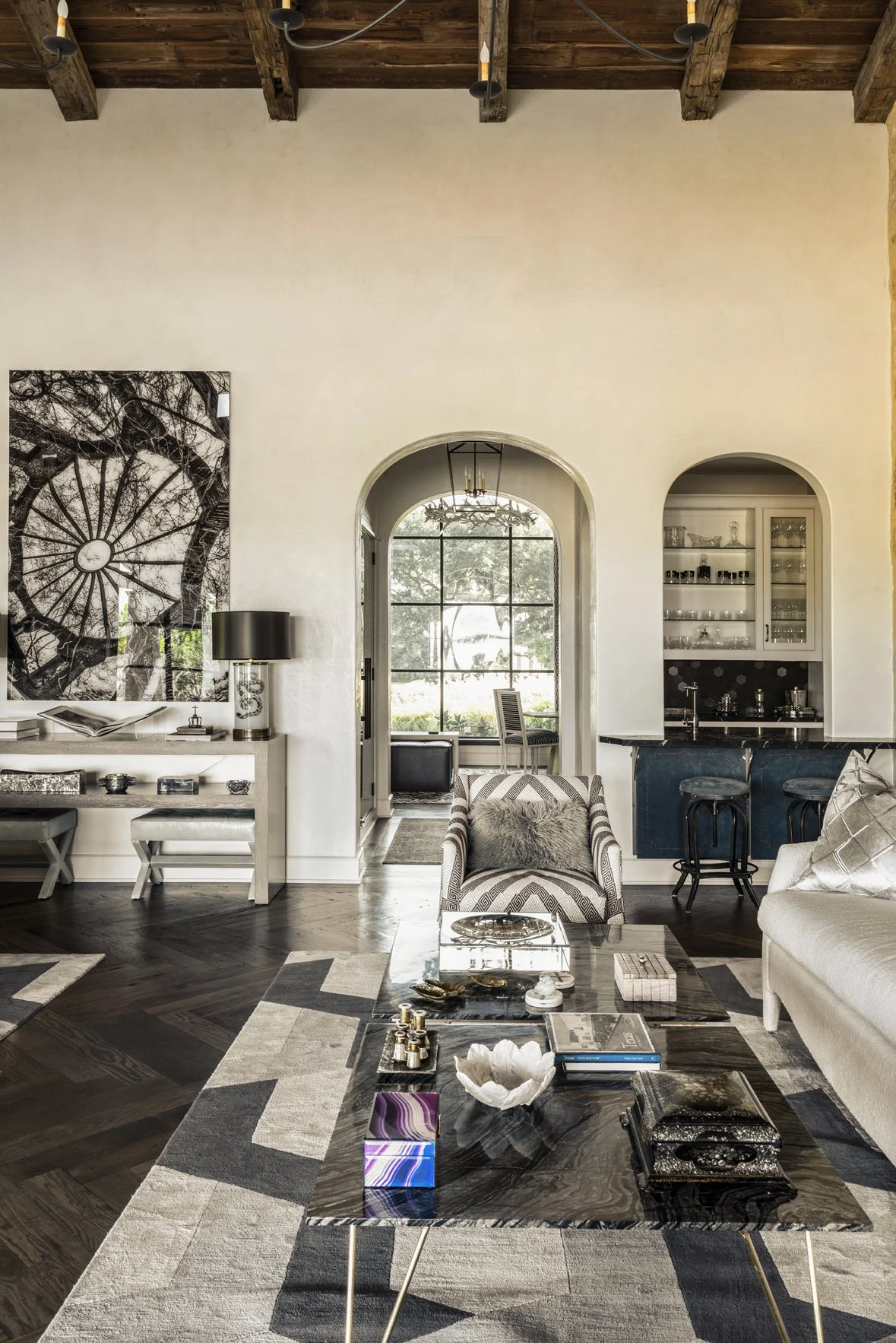 Modern ranch great room with arched openings, dark wood floors, graphic rugs, tailored seating and a built-in bar.