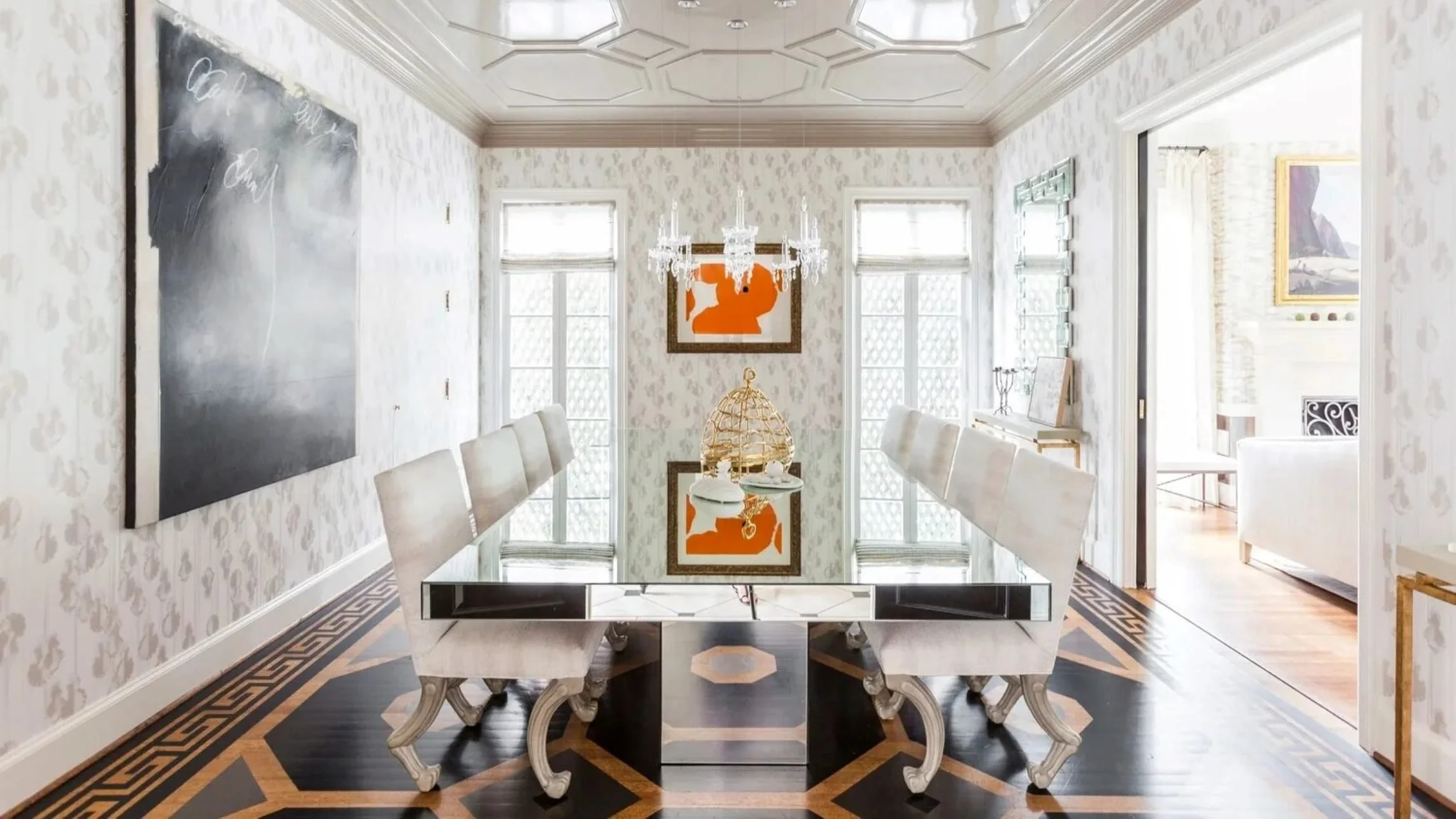 Luxury dining room at the Delmonte II residence with a mirrored table, crystal chandelier and graphic patterned floor.