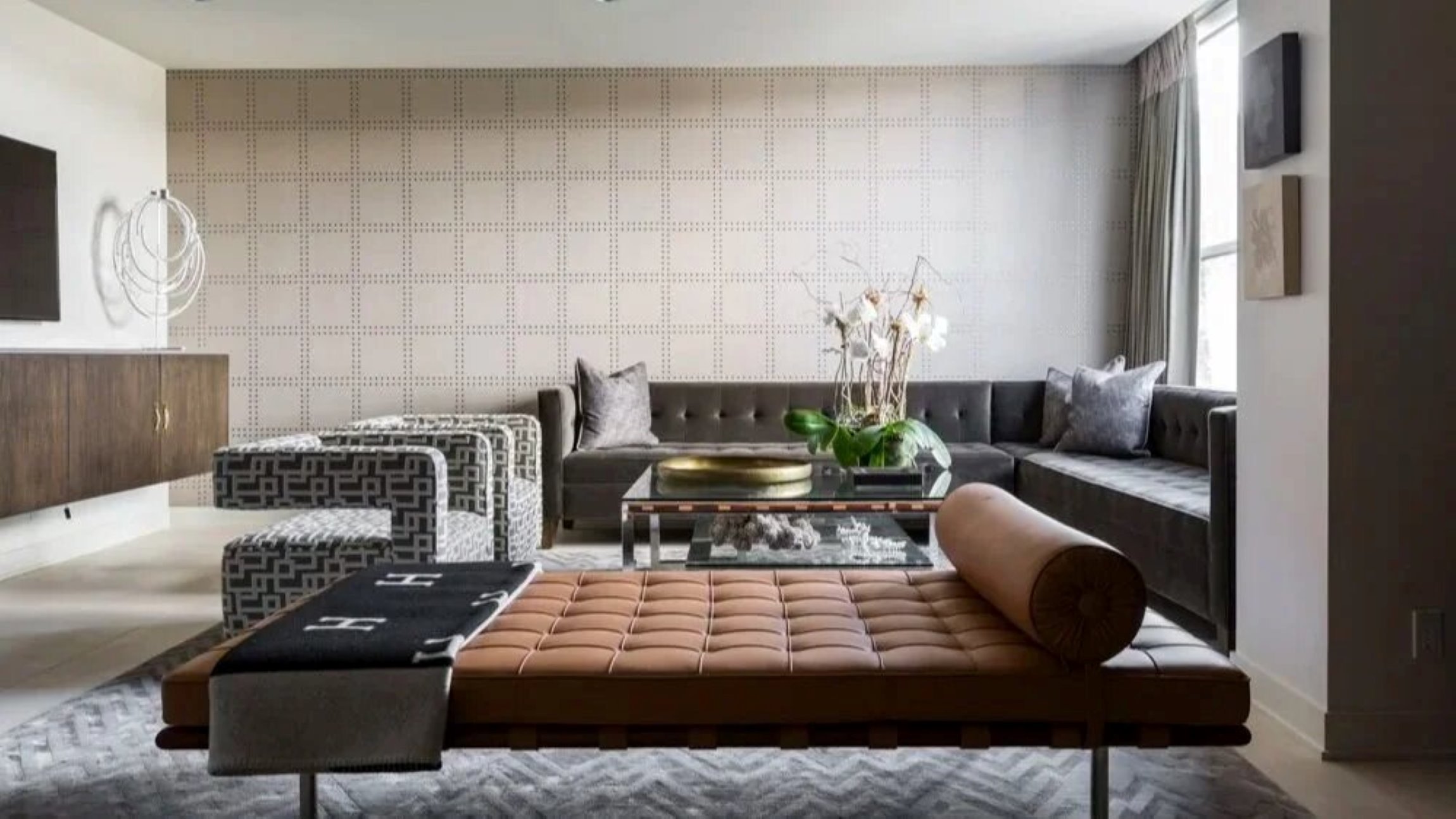 Greenway residence living room with a tan leather daybed, grey sectional seating and graphic patterned armchairs.