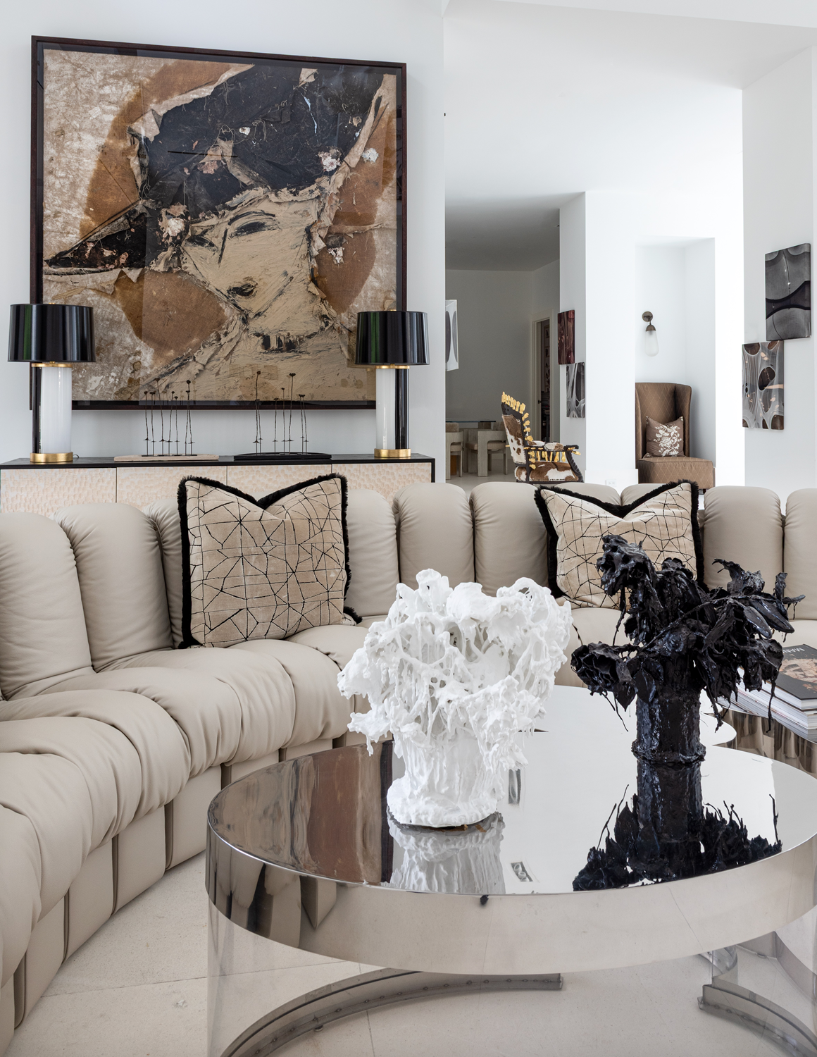 Modern luxury home in Houston living room with a sculptural De Sede sofa, mirrored coffee table and large abstract art.
