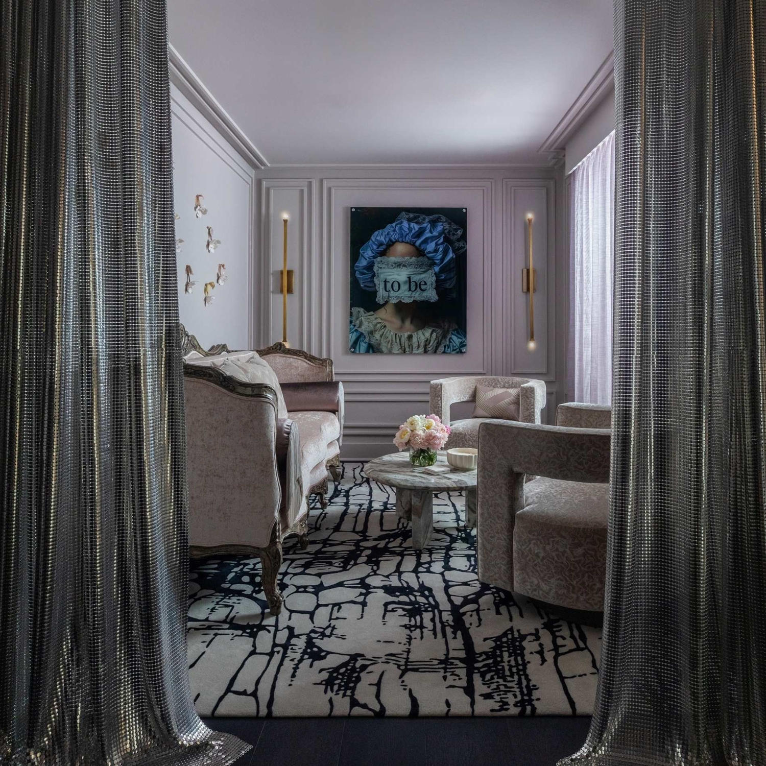 Wellness clinic Houston lounge framed by metallic curtains, with upholstered seating, patterned rug and contemporary art.