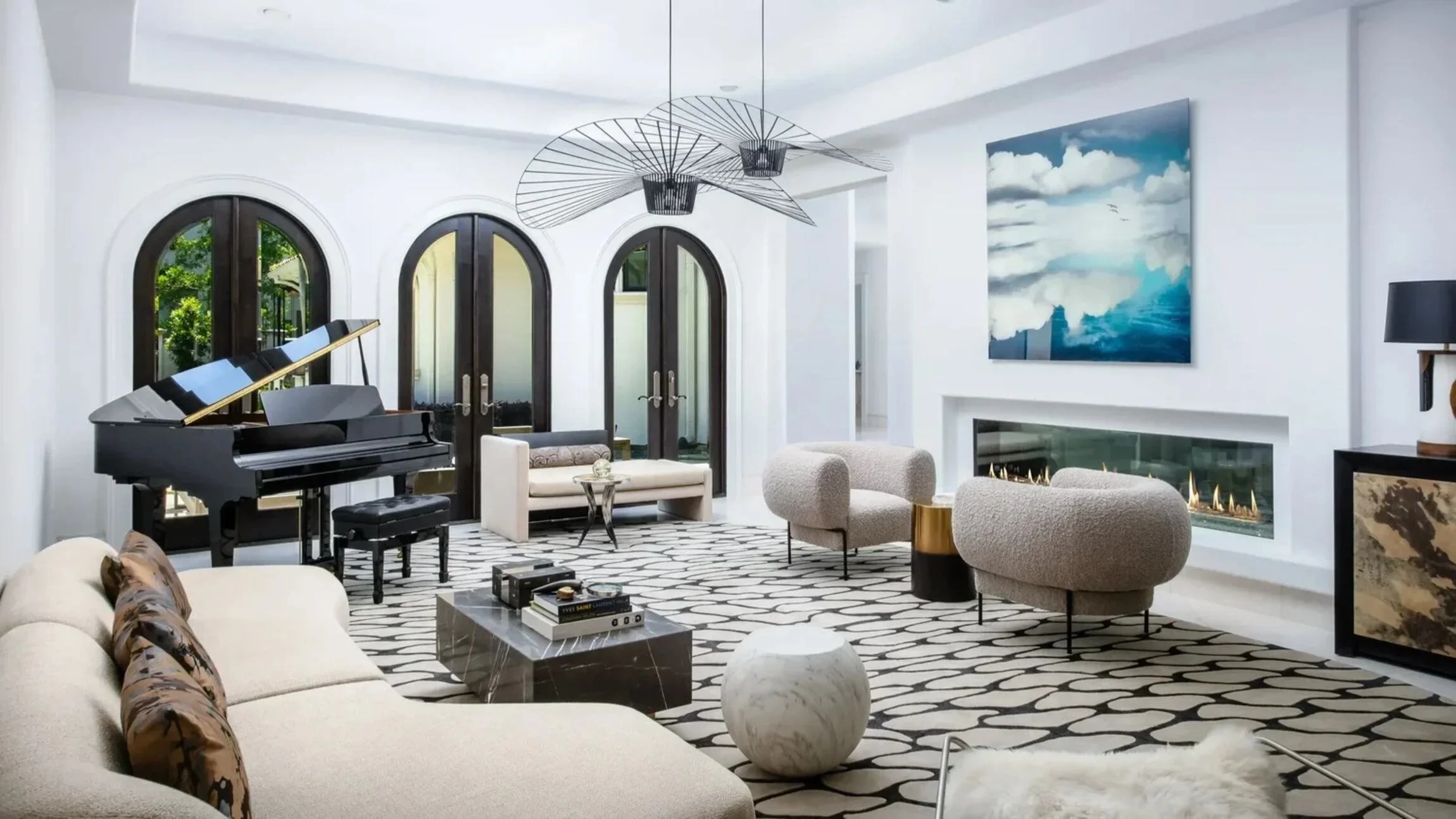 Saddlecreek residence living room with a grand piano, curved bouclé chairs, arched doors and contemporary artwork.