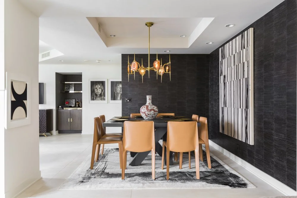Interior designer New York West Village dining room with cognac chairs, dark textured walls and sculptural pendant lighting.