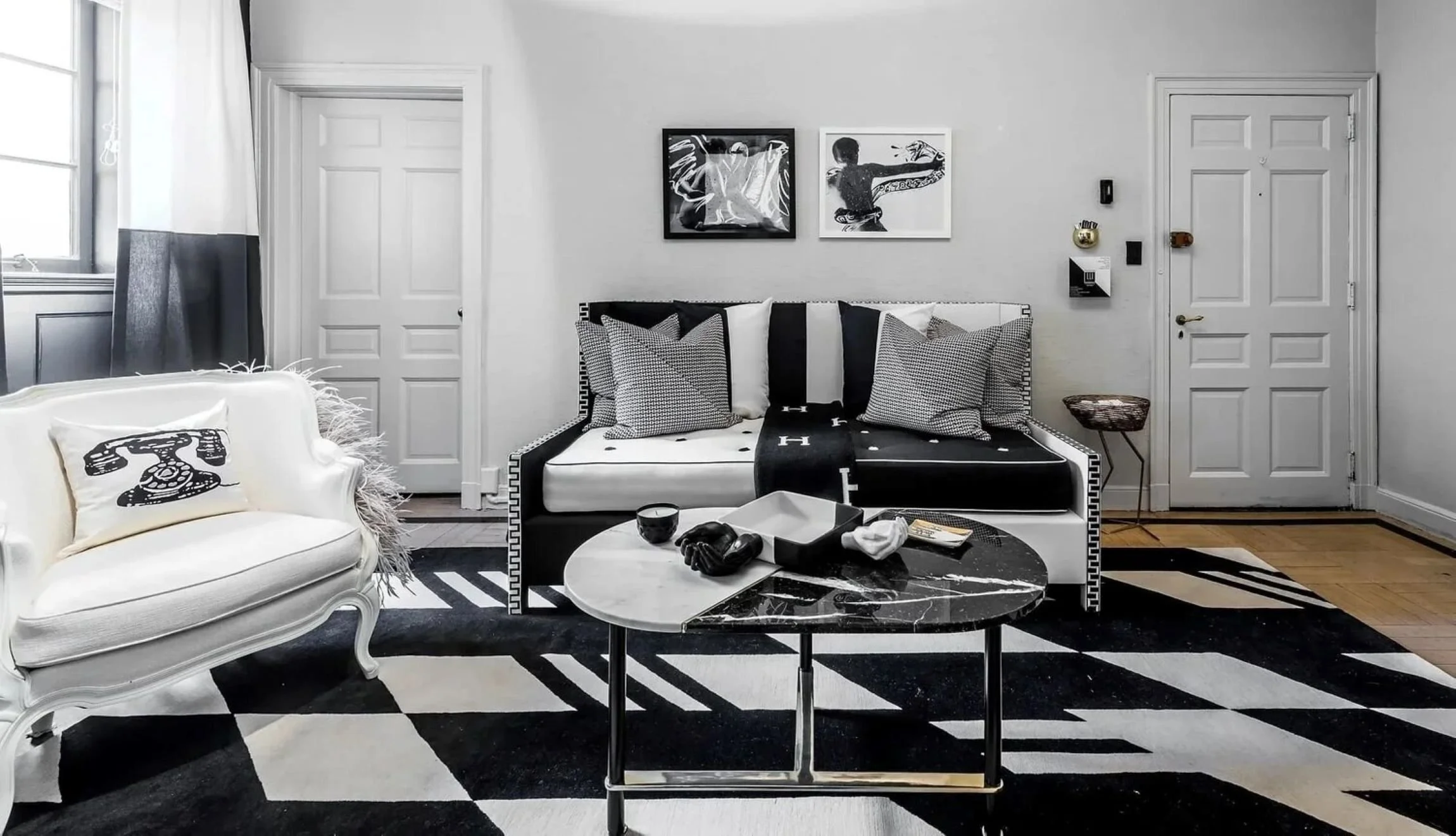 Holiday House showcase sitting room with monochrome furnishings, a graphic rug and contemporary black-and-white art.