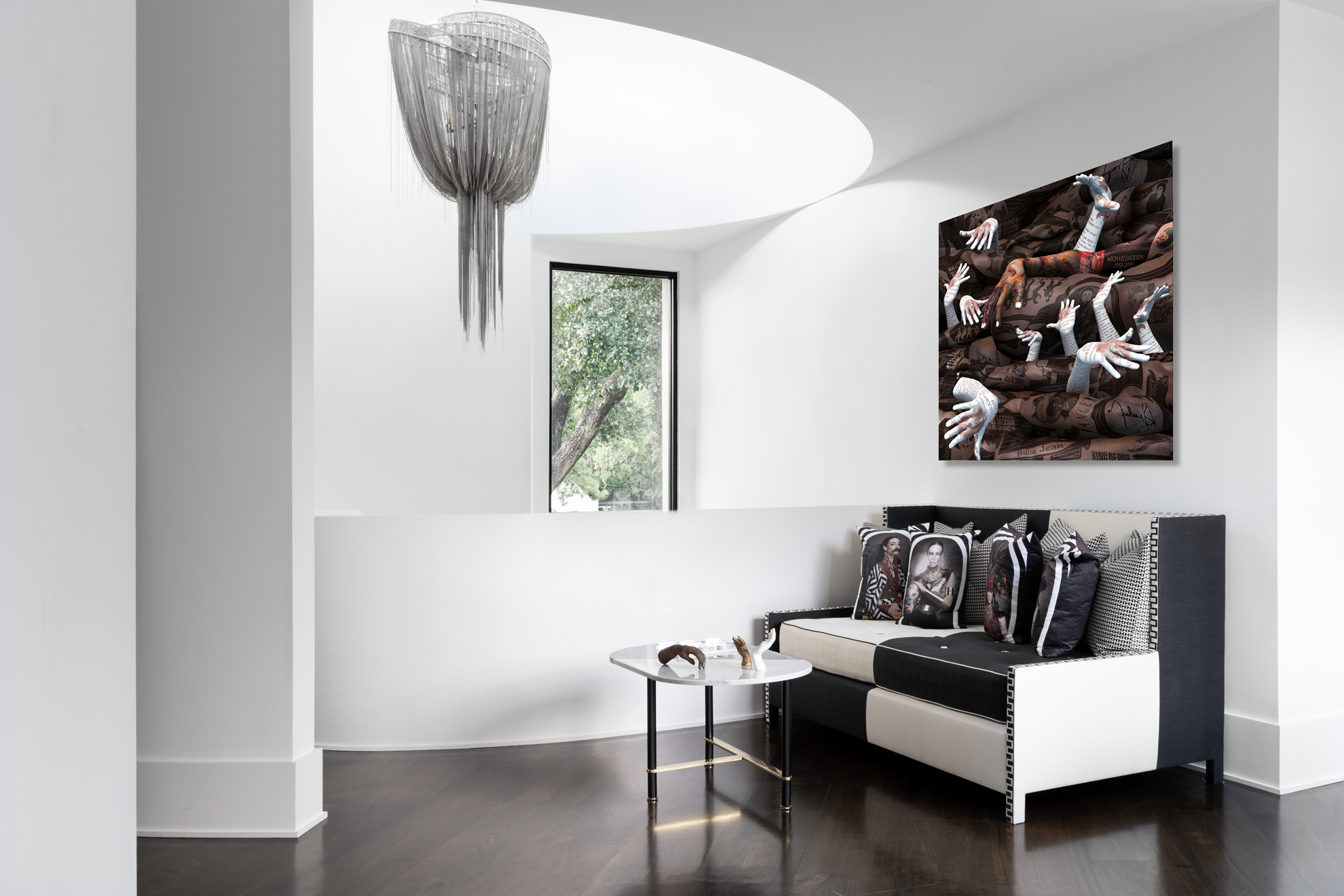 Modern luxury home in Houston sitting area with a black-and-white sofa, portrait cushions and contemporary artwork.