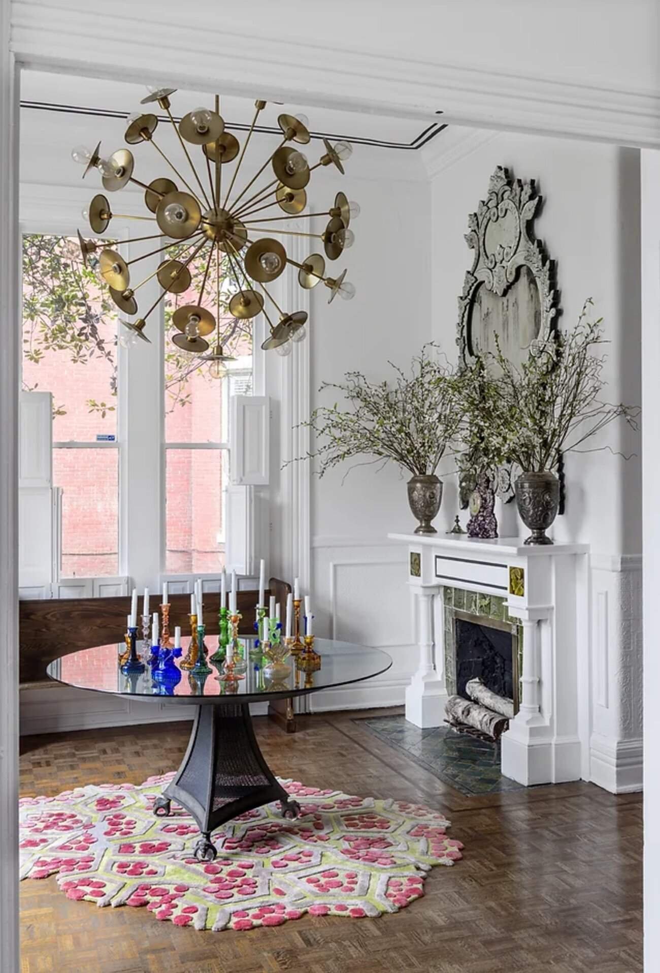 Cherokee Italianate mansion dining room with a sculptural brass chandelier, colourful glassware and an ornate fireplace.