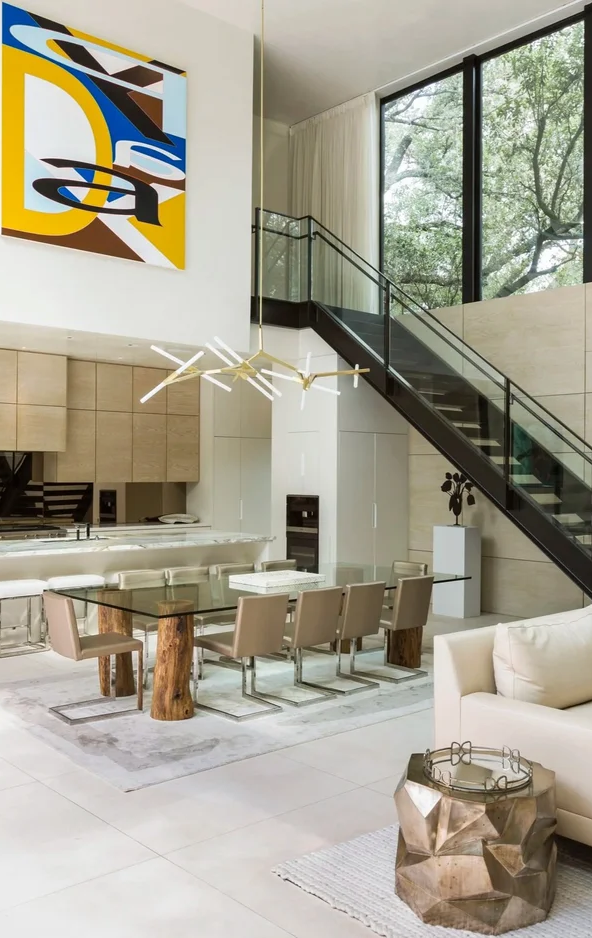 Luxury residential interior design in Houston with double-height glass walls, sculptural lighting, and open-plan dining