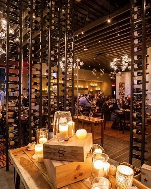 Commercial interior design project at Vallone's restaurant, with a dramatic wine room and floor-to-ceiling bottle racks.