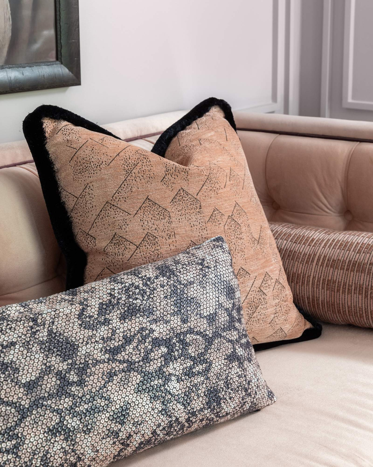 Wellness clinic Houston waiting area detail with blush patterned cushions and a sequinned lumbar pillow on a pink sofa.