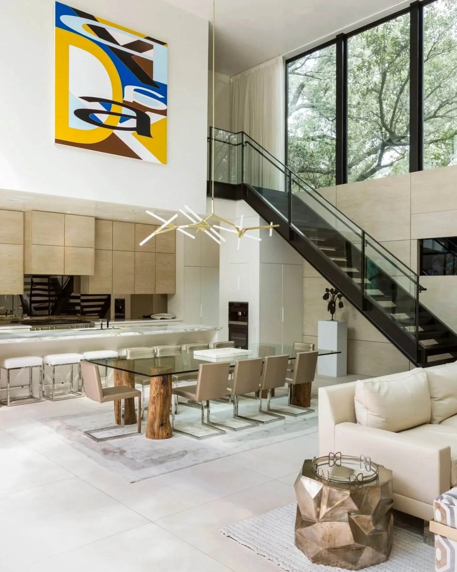 Double-height Stanmore residence with an open-plan kitchen, dining area, contemporary art and black steel staircase.