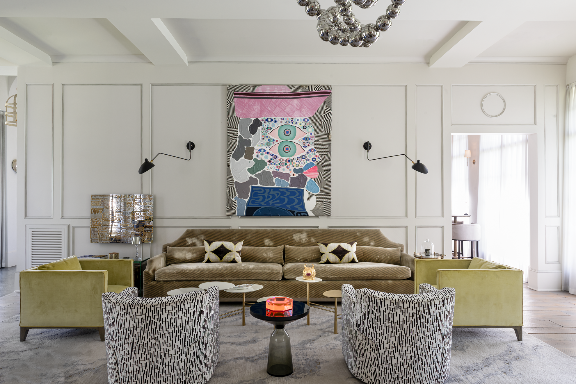 French country home in Houston sitting room with a velvet sofa, patterned armchairs, sculptural lighting and bold artwork.