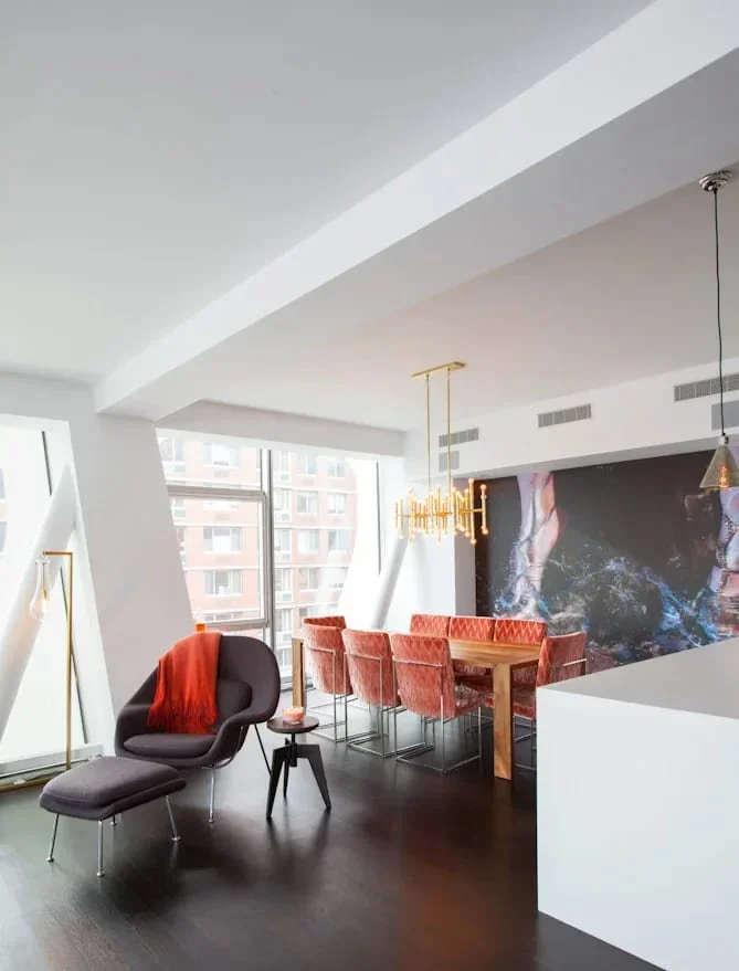 Interior designer New York Financial District apartment with coral dining chairs, sculptural lighting and modern art.