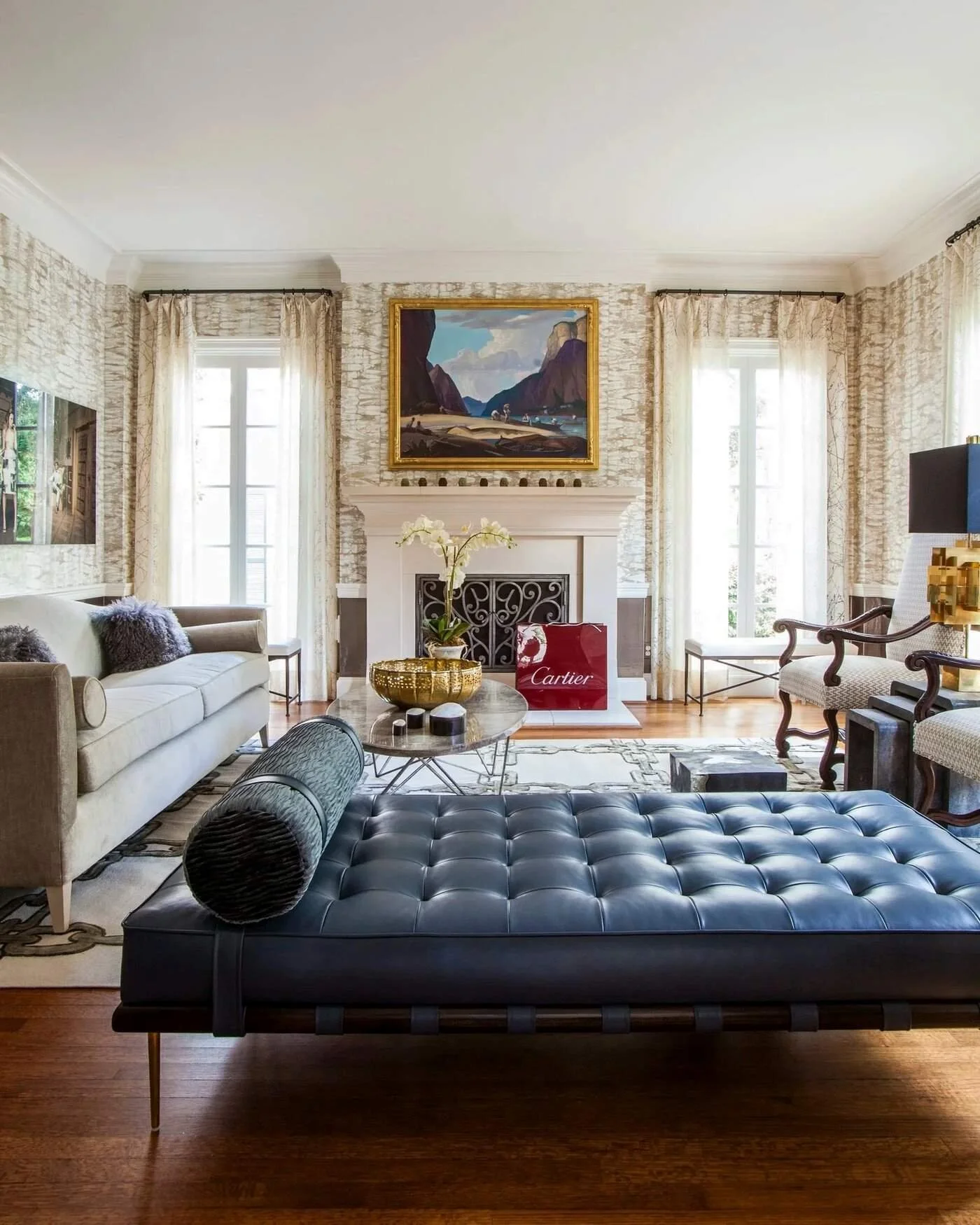 Delmonte II residence living room with a blue leather daybed, layered artwork and traditional architectural detailing.