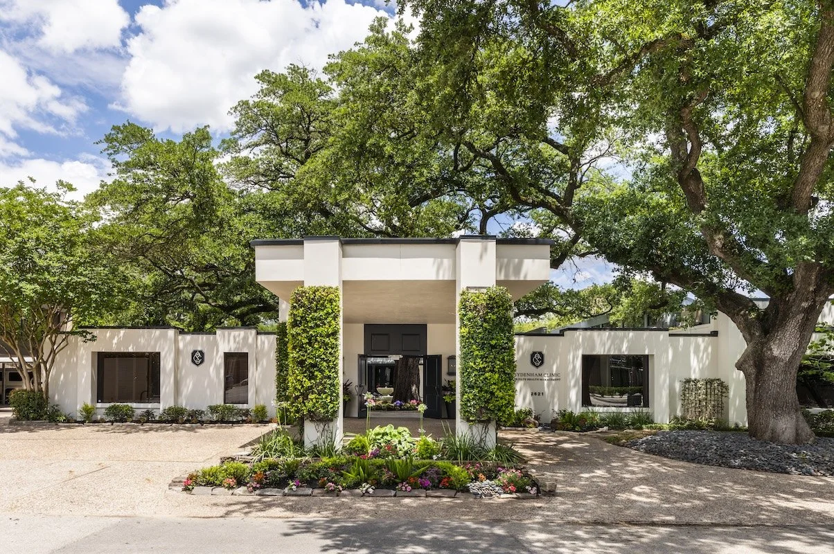 Commercial interior design Houston project at Sydenham Clinic, with a landscaped entrance and modern white facade.