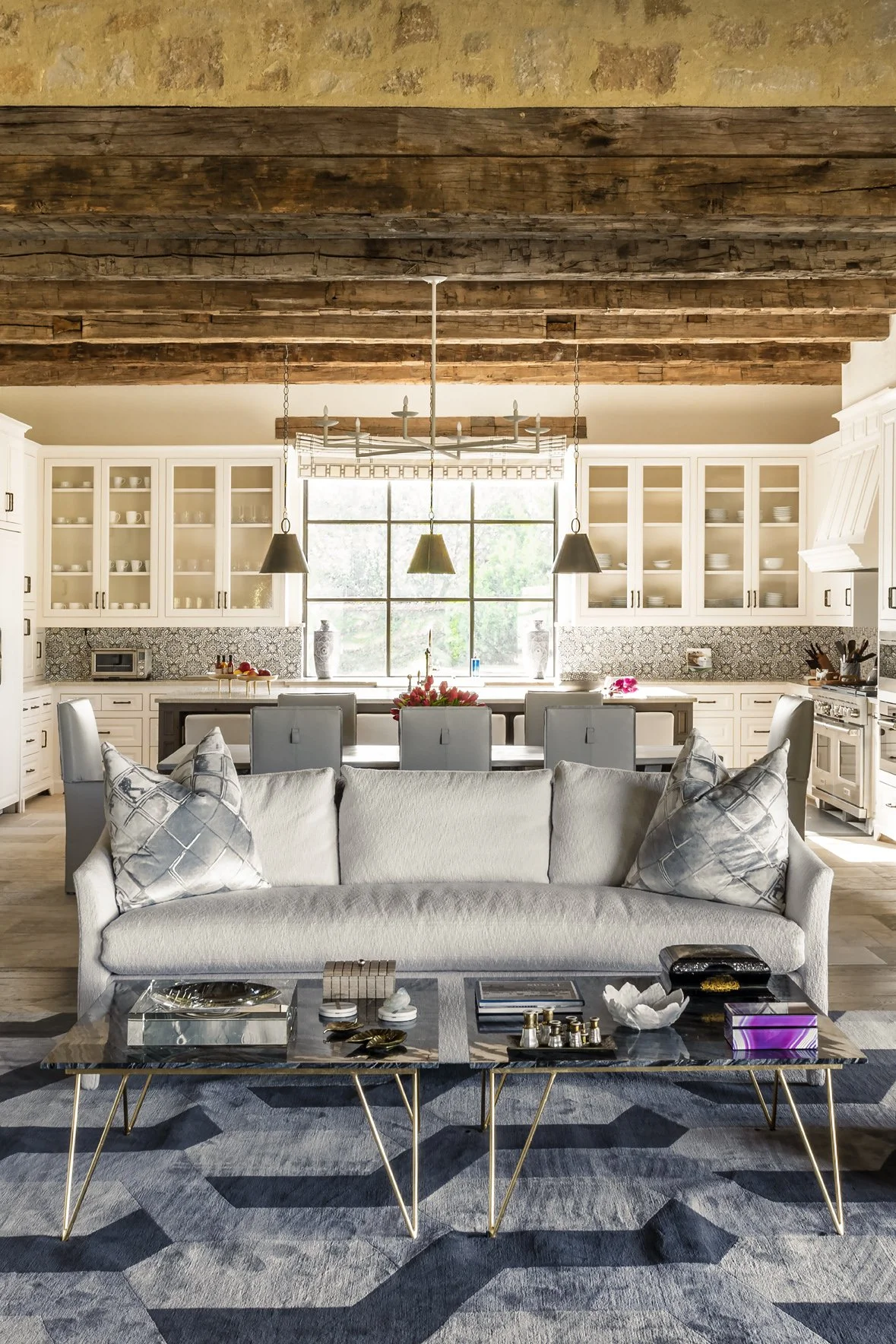 Modern ranch interior design connects the Houston Oaks great room and kitchen with reclaimed beams and graphic furnishings.