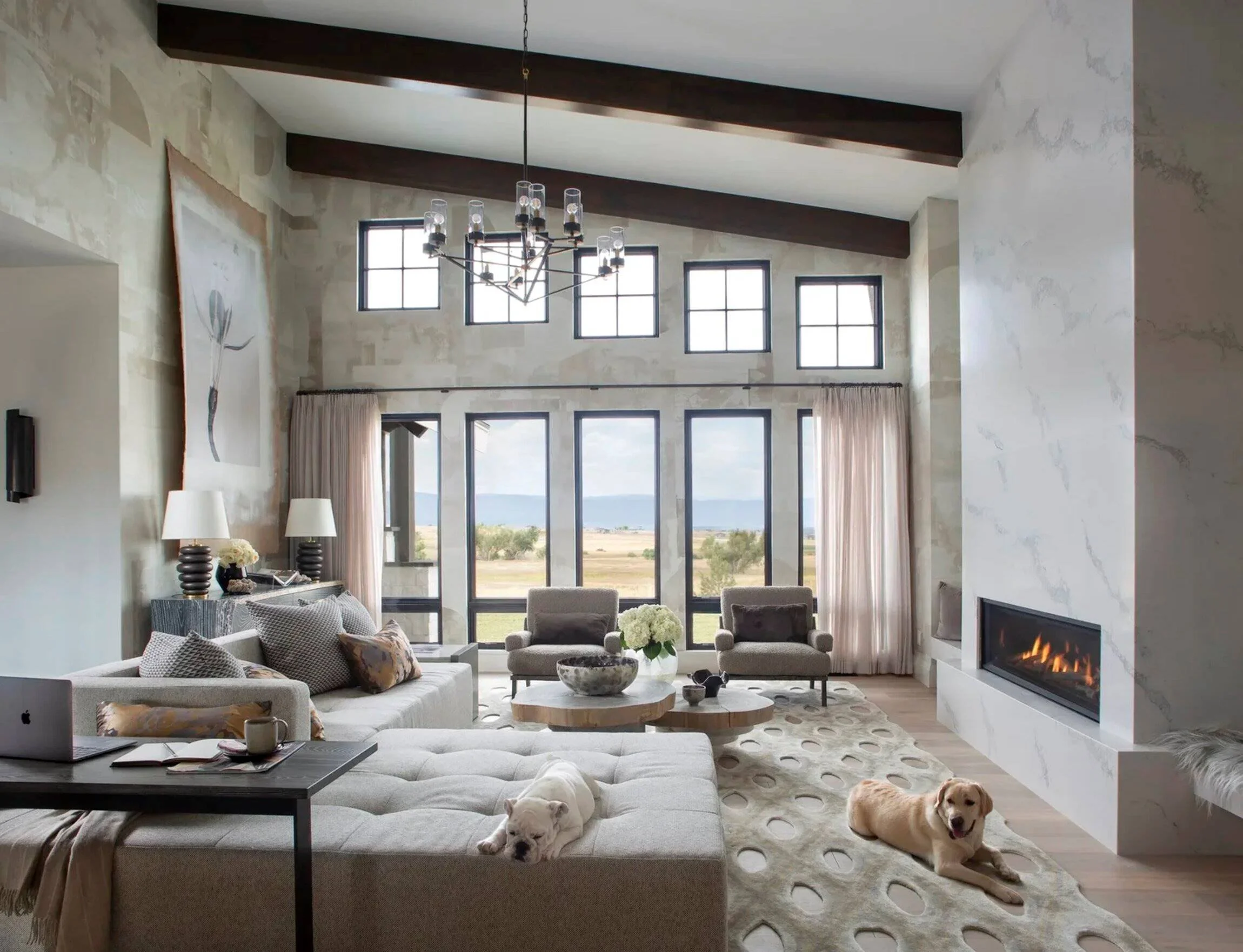 Colorado residence living room with double-height windows, a marble fireplace and expansive landscape views.