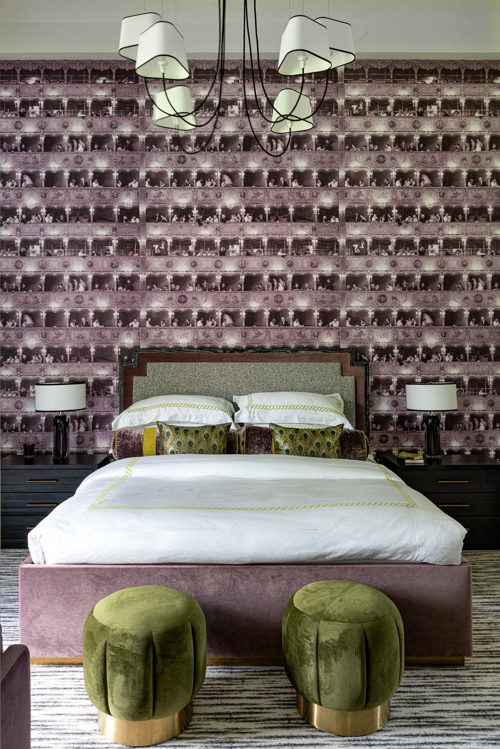 French country home in Houston guest bedroom with purple wall covering, green velvet stools and a black chandelier.