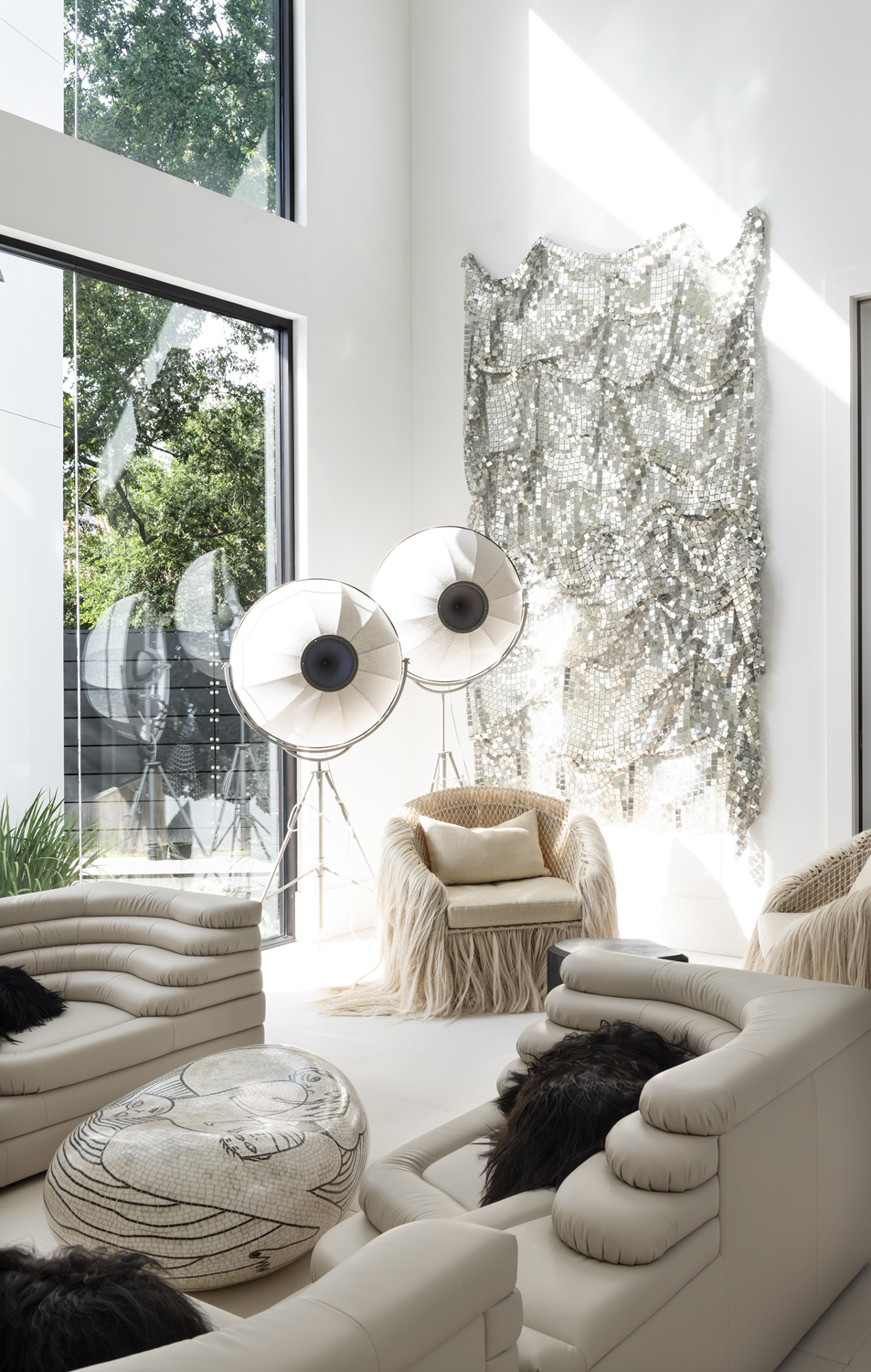 Modern luxury home in Houston lounge with sculptural cream seating, tripod lamps and shimmering metallic wall art.